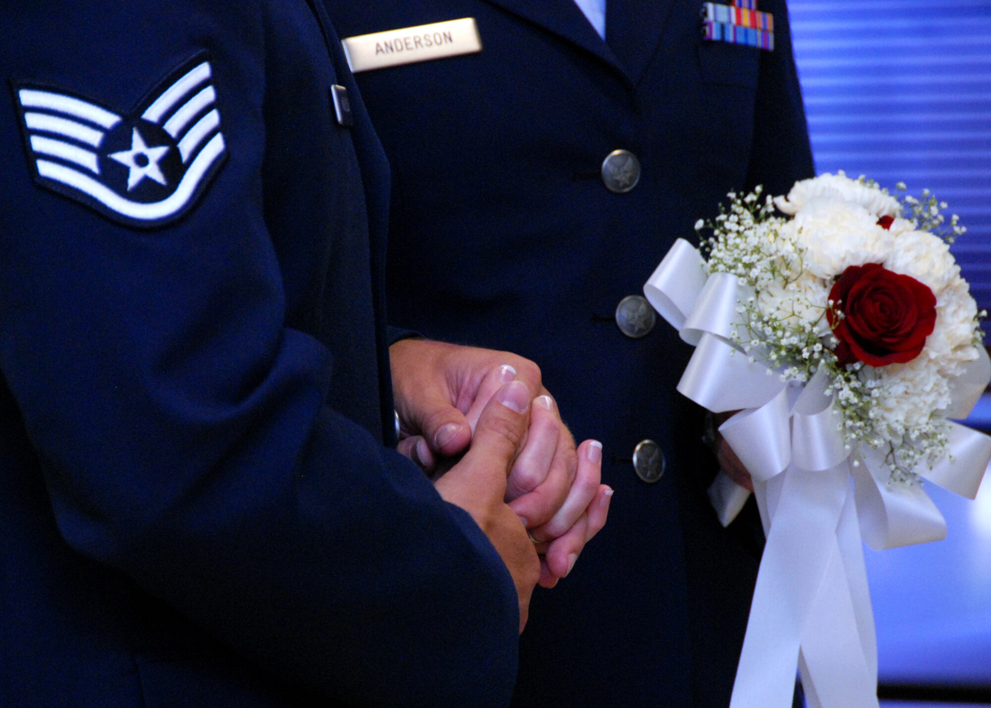 Staff Sgt.  Jake Anderson, 1st Special Operations Component Maintenance Squadron, and his wife hold hands during renewal of their vows at a surprise ceremony July 26 at Eglin Air Force Base, Fla.  Sergeant Anderson surprised 2nd Lt. Angela Anderson, 96th Inpatient Squadron, by putting together an official military-style wedding for their first anniversary.  (U.S. Air Force photo/Samuel King Jr.)