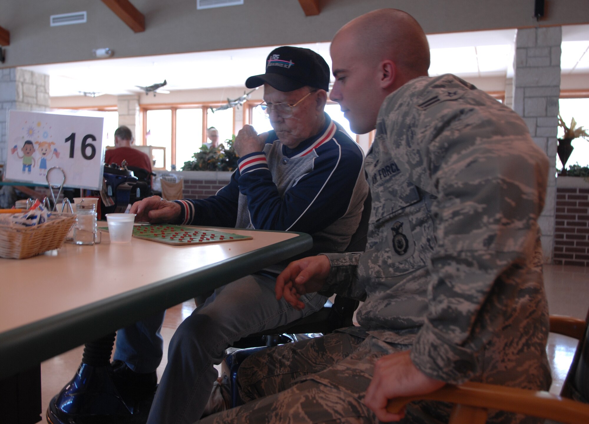 WARRENSBURG, Mo. -- Airman 1st Class Matt Bushek, 509th Security Forces Squadron, and William Eckinger play a round of Bingo at the Missouri Veteran's Home in Warrensburg, Mo., July 19.  Airman Bushek and classmates from the First Term Airman Center visited the home to blend the values of America's greatest generation with the innovation and vigor of the Air Force's newest members.(U.S. Air Force photo by Airman 1st Class Torey Griffith) (Released)