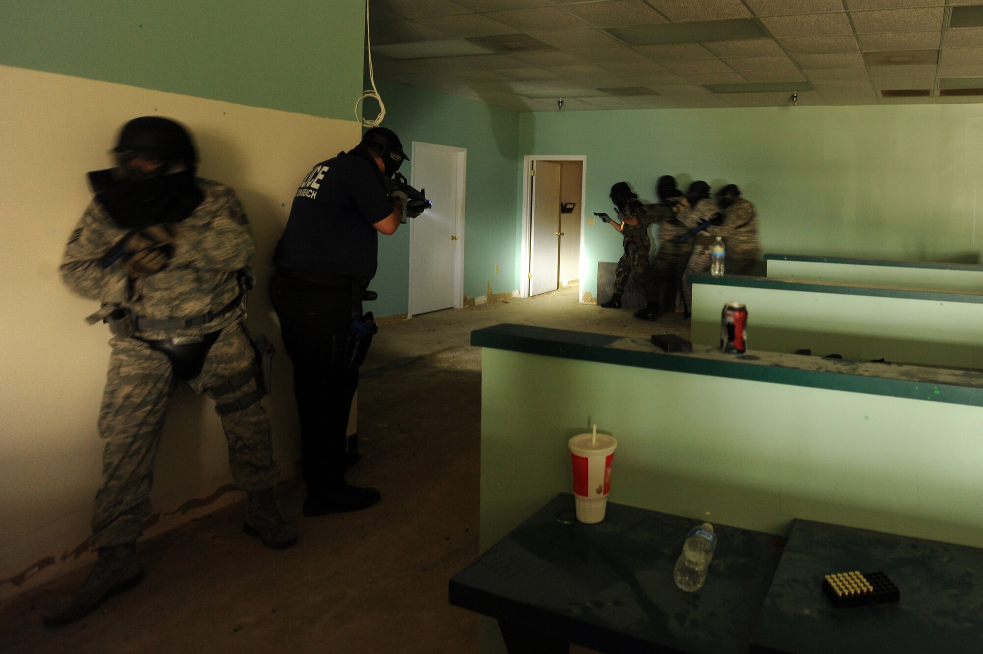 Members of the 1st Special Operations Security Forces Squadron and the Fort Walton Beach Police Department clear a training building in Okaloosa County, Fla., during active shooter training July 22, 2010. The training put law enforcement teams of various sizes against multiple unknown threats armed with M-9s, M-16s, and other weapons converted to fire simulated ammunition that marks targets with brightly colored dye. (DoD photo by U. S. Air Force Senior Airman Matthew Loken)