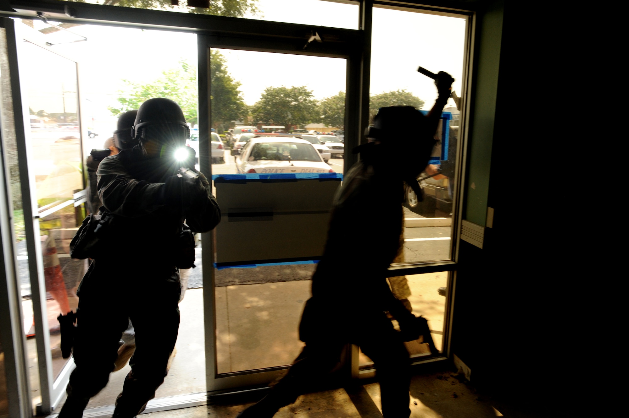 1st Special Operations Security Forces Squadron Airmen enter a training building in Okaloosa County, Fla., during active shooter training July 22, 2010.The training put law enforcement teams of various sizes against multiple unknown threats armed with M-9s, M-16s, and other weapons converted to fire simulated ammunition that marks targets with brightly colored dye. (DoD photo by U. S. Air Force Senior Airman Matthew Loken)