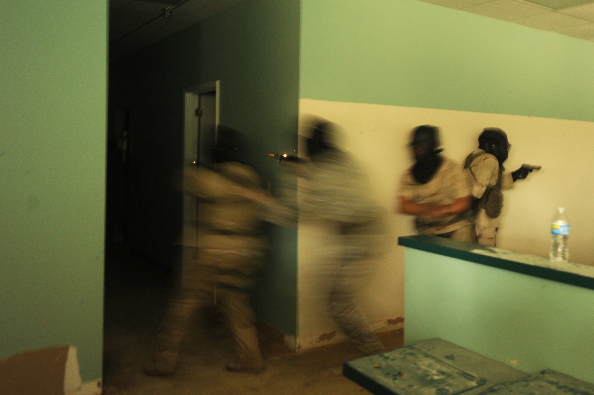 Members of the 1st Special Operations Security Forces Squadron and the Fort Walton Beach Police Department clear a training building in Okaloosa County, Fla., during active shooter training July 22, 2010. The training put law enforcement teams of various sizes against multiple unknown threats armed with M-9s, M-16s, and other weapons converted to fire simulated ammunition that marks targets with brightly colored dye. (DoD photo by U. S. Air Force Senior Airman Matthew Loken)