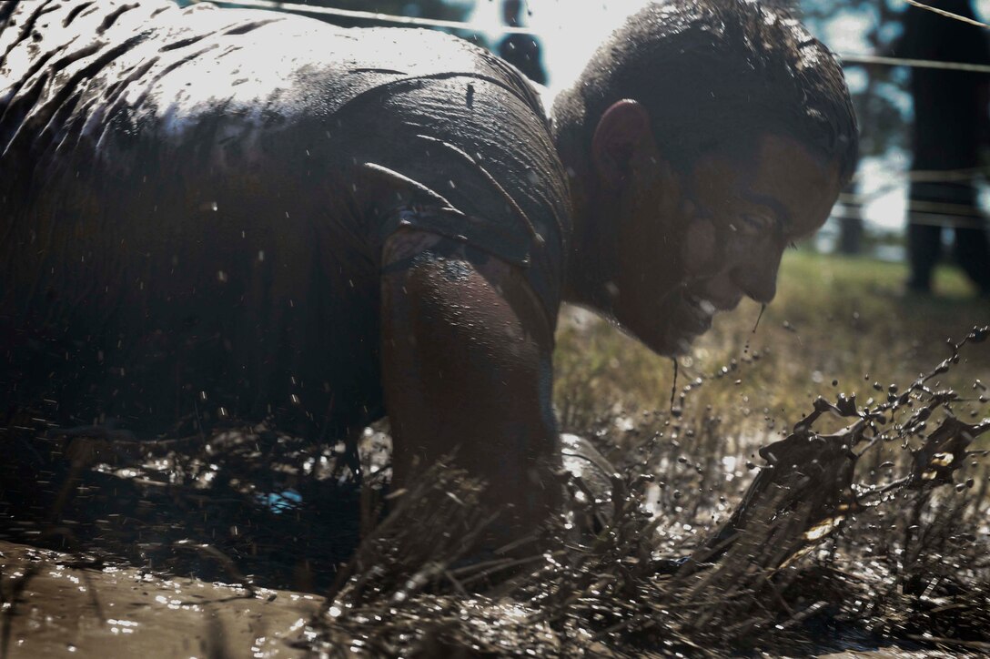 ELLSWORTH AIR FORCE BASE, S.D. - Airman 1st Class Jason Peters, 28th Logistics Readiness Squadron vehicle operator, begins the low crawl obstacle of the Ultimate Challenge during the base picnic, July 23. Nearly 30 Airmen and civilian employees of 28 LRS competed in the challenge. (U.S. Air Force photo/Airman 1st Class Corey Hook)