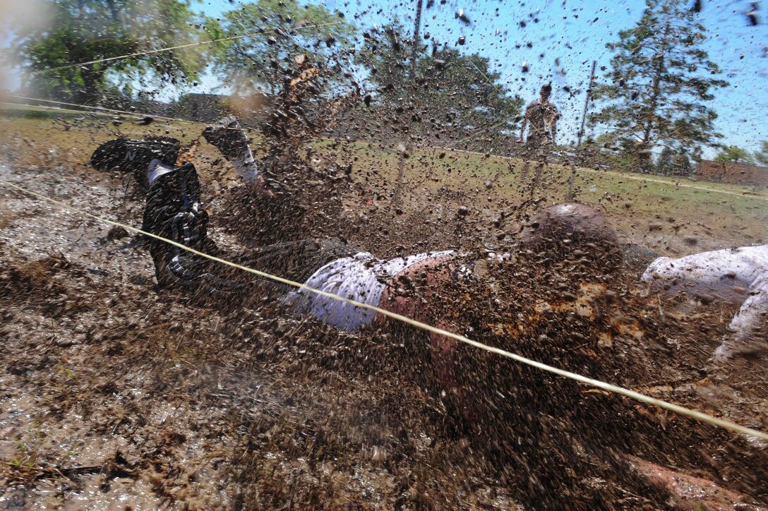 ELLSWORTH AIR FORCE BASE, S.D. - Staff Sgt. Derek Winters, 28th Maintenance Squadron avionics backshop technician, begins the low crawl obstacle of the Ultimate Challenge during the base picnic, July 23. More than twenty teams of two competed in the challenge. (U.S. Air Force photo/Airman 1st Class Corey Hook)