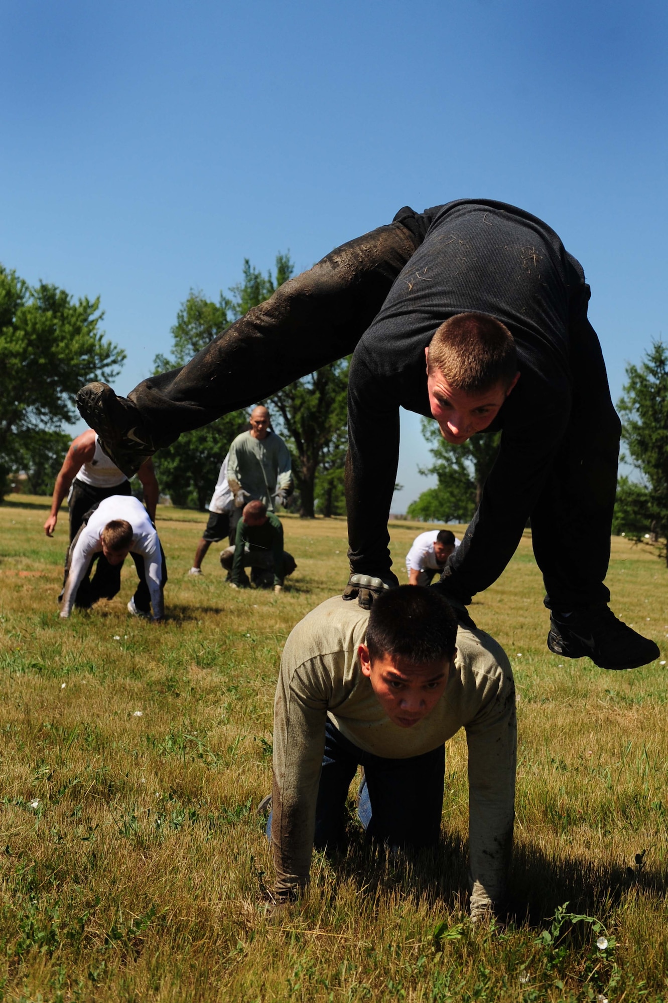 ELLSWORTH AIR FORCE BASE, S.D. - (Above) Senior Airman Brian Craddock jumps over Airman 1st Class Rene Soriano during the leap frog obstacle in the Ultimate Challenge during the base picnic, July 23. Both Airmen are assigned to the 28th Logistics Readiness Squadron as vehicle operators. (U.S. Air Force photo/Airman 1st Class Corey Hook)
