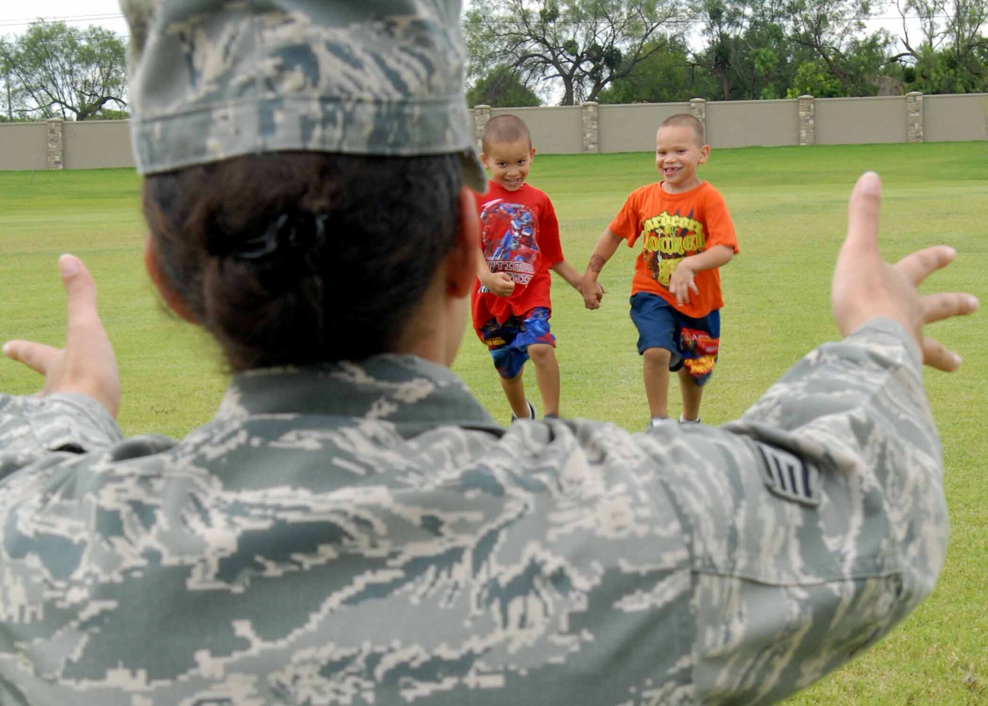 Staff Sgt. Christina Cordova, 17th Training Wing staff, greets her 5-year-old twins, Anthony and Christopher Marquez, after work July 27. The Air Force's year-long celebration honoring military families like Sergeant Cordova's comes to an end in July. The Year of the Air Force Family finale is Aug. 20 at 7 p.m. on the field between the Event Center and Bowling Center. (U.S. Air Force photo/Senior Airman Tong Duong)