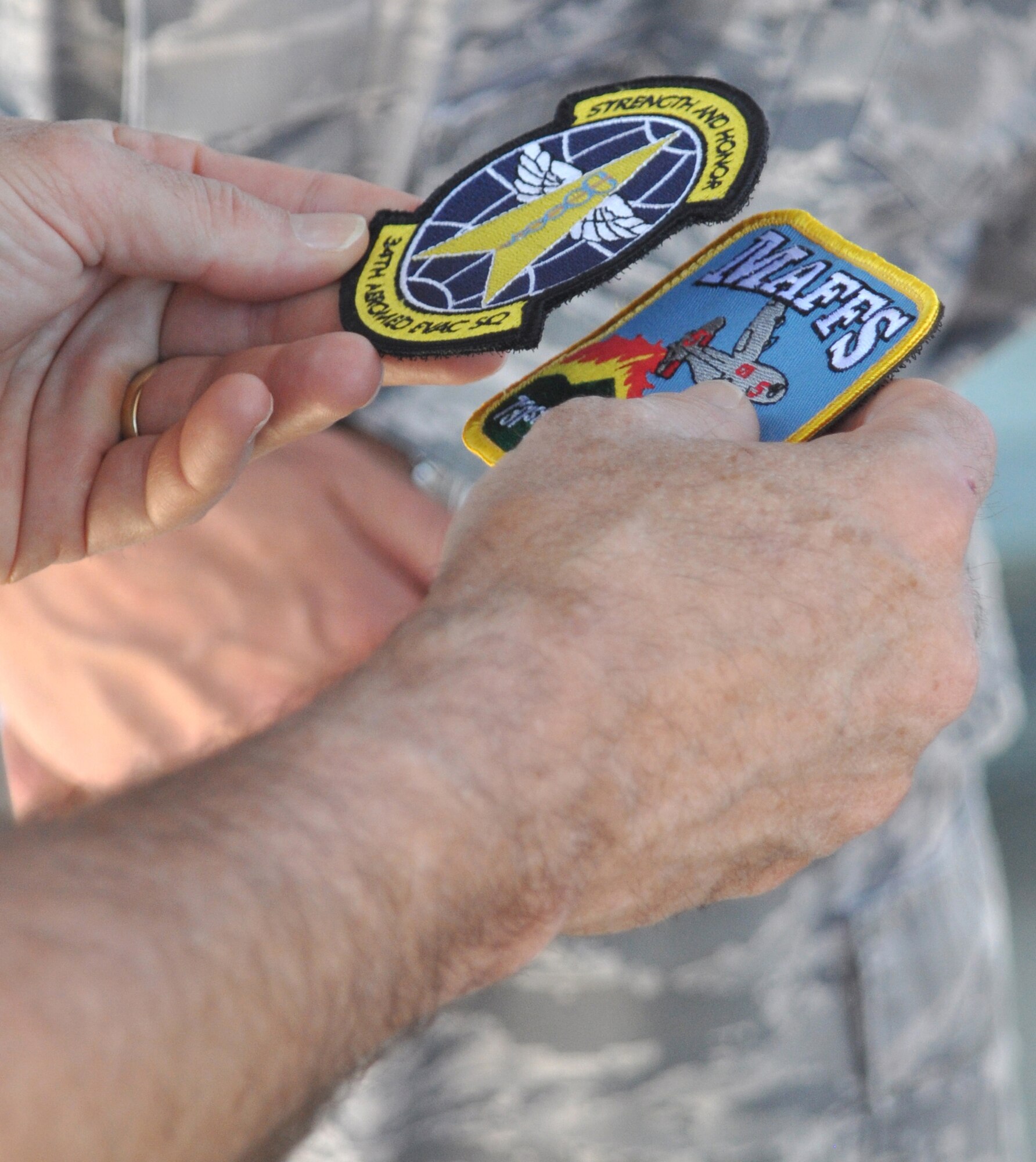 Navy Adm. James A. Winnefeld, Jr., holds both the 34th Aeromedical Evacuation Squadron and the 302nd Airlift Wing’s Modular Airborne Firefighting System patches in his hand after being presented them from 302nd AW leadership July 26 at Peterson Air Force Base, Colo. Admiral Winnefeld, commander of the North American Aerospace Defense Command and U.S. Northern Command, together with senior leaders from both organizations, visited the Air Force Reserve’s 302nd AW to gain a better understanding of the specialized missions the AF Reserve supports, to include aeromedical evacuation and aerial firefighting. The visit also showcased the capabilities Air Force Reservists can provide to civilian-related missions if called upon. (U.S. Air Force photo/Staff Sgt. Stephen J. Collier)