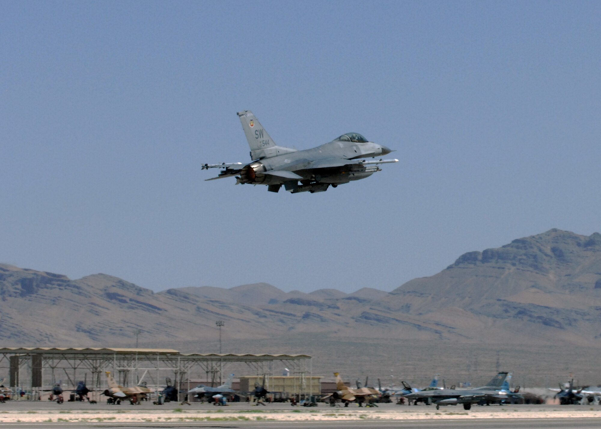 NELLIS AIR FORCE BASE, Nev. -- An F-16 from the 77th Fighter Squadron, Shaw Air Force Base, S.C. takes off from the runway for Red Flag-Nellis July 21, 2010. Red Flag is a realistic combat training exercise involving the air forces of the United States and its allies. The exercise is hosted north of Las Vegas on the Nevada Test and Training Range--the U.S. Air Force's premier military training area with more than 12,000 square miles of airspace and 2.9 million acres of land. With 1,900 possible targets, realistic threat systems and an opposing enemy force that cannot be replicated anywhere else in the world, Nellis and the NTTR are the home of a "peacetime battlefield," providing combat air forces with the ability to train to fly, fight and win together. (U.S. Air Force photo by Airman 1st Class Daniel Phelps)
