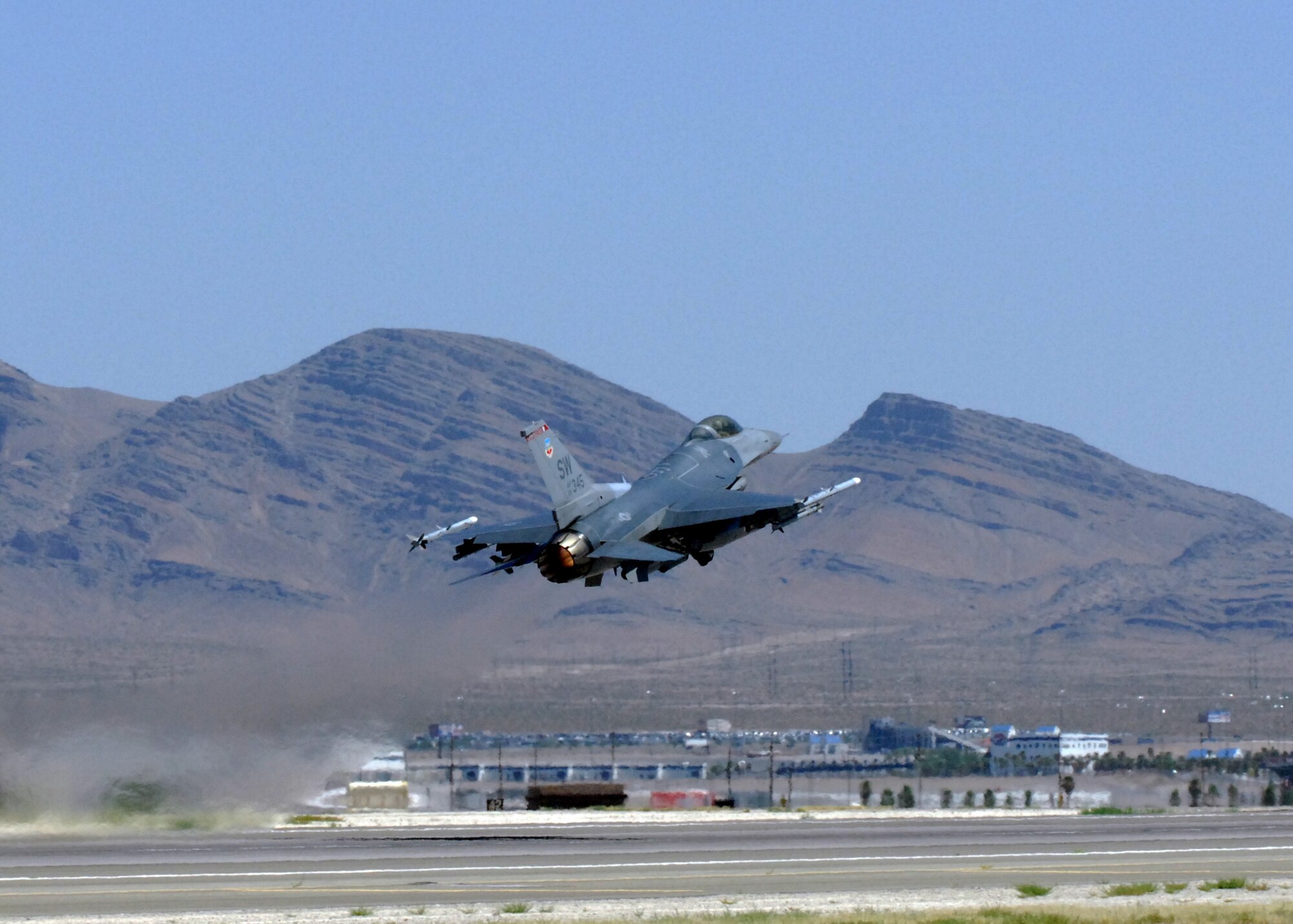 NELLIS AIR FORCE BASE, Nev. -- An F-16 from the 77th Fighter Squadron, Shaw Air Force Base, S.C. takes off from the runway for Red Flag-Nellis July 21, 2010. Red Flag is a realistic combat training exercise involving the air forces of the United States and its allies. The exercise is hosted north of Las Vegas on the Nevada Test and Training Range--the U.S. Air Force's premier military training area with more than 12,000 square miles of airspace and 2.9 million acres of land. With 1,900 possible targets, realistic threat systems and an opposing enemy force that cannot be replicated anywhere else in the world, Nellis and the NTTR are the home of a "peacetime battlefield," providing combat air forces with the ability to train to fly, fight and win together. (U.S. Air Force photo by Airman 1st Class Daniel Phelps)
