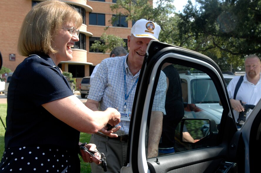 Dr. Virginia Short, acting Medical Center director opens the door to the newly donated vehicles at the Veteran Association Medical Center, July 26. Two 2010 Ford Explorer were donated to the medical center to help provide veterans with transportation to the facility. (U.S. Air Force photo by Senior Airman Brittany Y. Bateman)