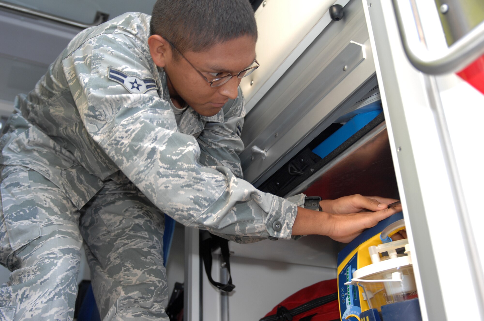 WHITEMAN AIR FORCE BASE, Mo.,- Airman 1st Class Matthew Mendoza checks the battery level of a decompression sickness bottle during his morning ambulance-check routine Tuesday. The DCS bottle connects to pilots' masks when breathing problems occur and provides 100 percent oxygen during the transition from aircraft to ambulance. (U.S. Air Force photo by Airman 1st Cody H. Ramirez) (Released)