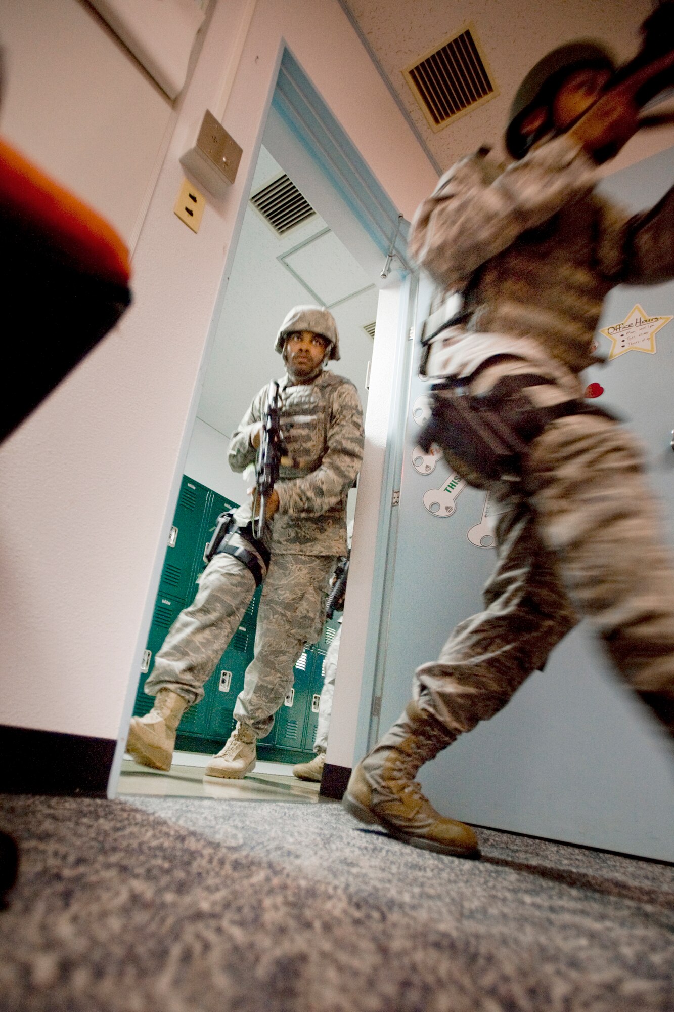 Airman 1st Class Steven Howard Jr., left, and Senior Airman Rolland Gould make their way into a classroom July 22, 2010, during high-risk response training at Misawa Air Base, Japan. The five-day course gave security forces Airmen interactive academics in class and newly developed, hands on techniques grounded in contemporary special weapons and tactics training. Airmen Howard and Gould are assigned to the 35th SFS at Misawa Air Base, Japan. (U.S. Air Force photo/Senior Airman Jamal D. Sutter)