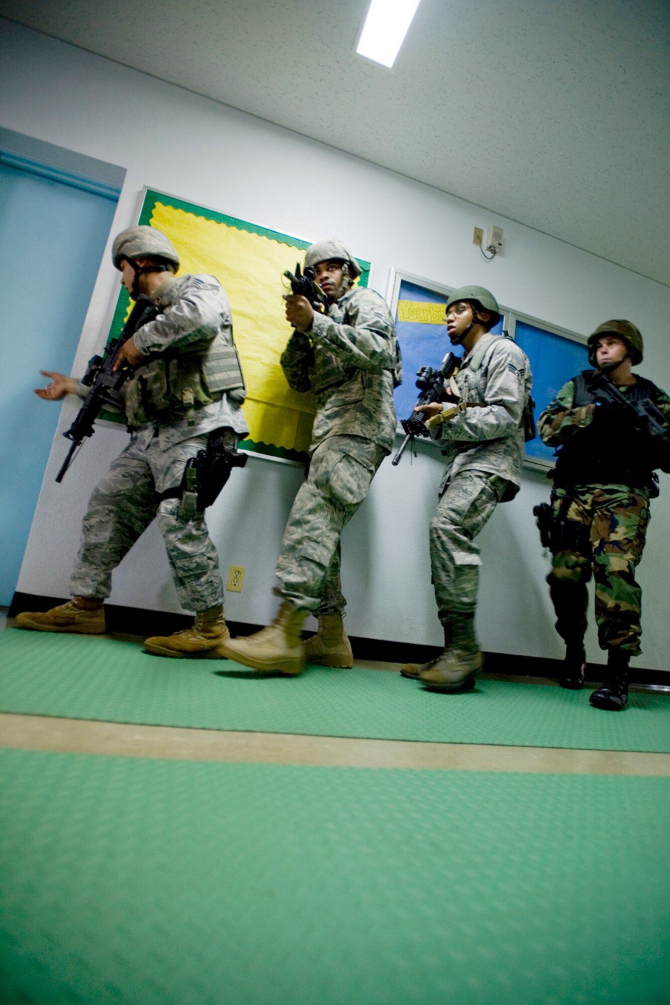 Staff Sgt. Anthony Santillan, Airman 1st Class Steven Howard Jr. and Senior Airman Rolland Gould along with Petty Officer 1st Class Jason Clark train on quick-reaction response tactics July 22, 2010, at Misawa Air Base, Japan. The training was part of a high-risk response program taught to base security members that will allow them to respond to an active shooter incident. The Airmen are assigned to the 35th Security Forces Squadron at Misawa AB, Japan, and Petty Officer Clark is the Naval Air Facility security operations supervisor. (U.S. Air Force photo/Senior Airman Jamal D. Sutter)