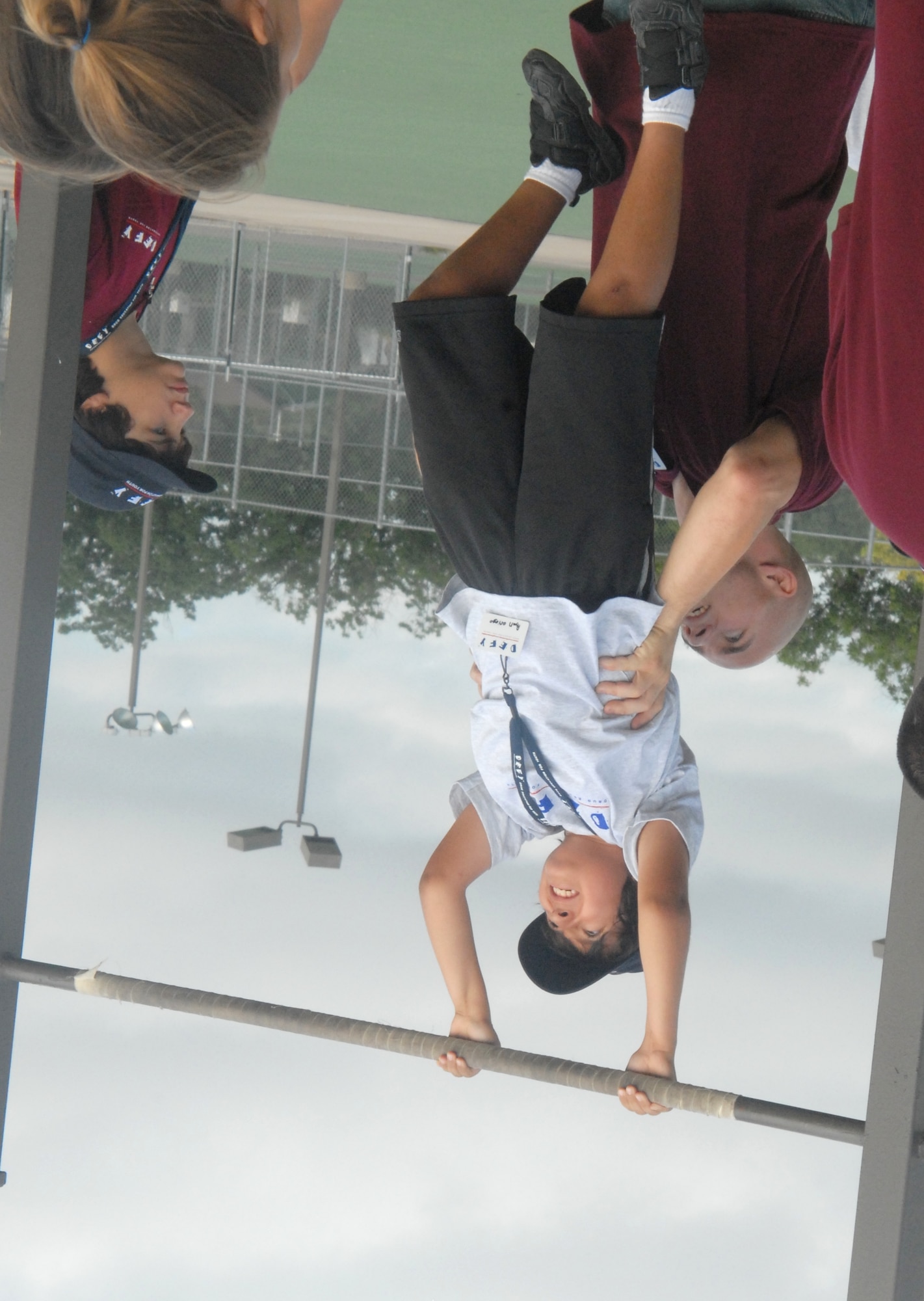 Marine Sgt. Bill Dolmer, helps DEFY camper Ryan Griego with pull ups during part one of the President's physical fitness challenge July 22. Sgt. Dolmer is one of eight volunteer mentors during the eight-day camp here. (U.S. Air Force photo/Connie Hempel)