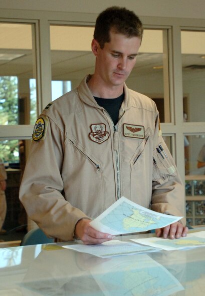 Capt. Scott Morrison, 905th Air Refueling Squadron pilot, reviews maps and flight plans before deploying on the last KC-135 deployer from Grand Forks Air Force Base July 26. This will be the last deployment for the KC-135s assigned to Grand Forks AFB due to the base’s transition from an aerial refueling mission to an unmanned aerial systems mission. (U.S. Air Force photo by Airman 1st Class Rachel Martinez)