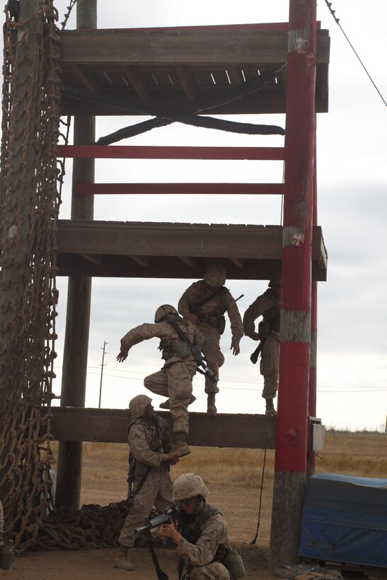 Recruits from Platoon 3275, Company M begin climbing the Sky Scraper obstacle on the Confidence Course during their Crucible.