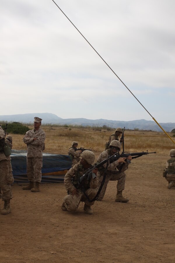 Pfc. Wendu Gebremichael, foreground, Platoon 3275, Co. M, listens to directions before providing part of a perimeter around the Sky Scraper obstacle on the Confidence Course.