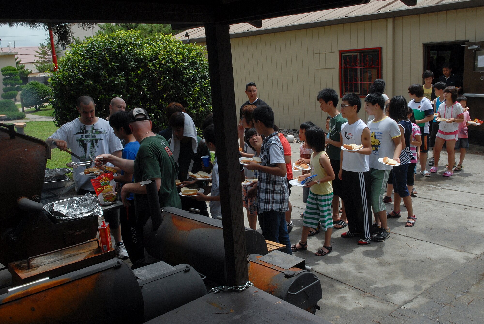 KUNSAN AIR BASE, Republic of Korea -- Wolf Pack members serve hot dogs, hamburgers and chicken legs to children from the Il Mag Won Orphanage during a Kid’s Day July 24. Sixty-eight children started their 30-day summer vacation off right with the Wolf Pack. The children played games, went for a swim and even met Sparky the Fire Dog. (U.S. Air Force photo/Senior Airman Roy Lynch)