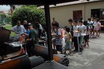 KUNSAN AIR BASE, Republic of Korea -- Wolf Pack members serve hot dogs, hamburgers and chicken legs to children from the Il Mag Won Orphanage during a Kid’s Day July 24. Sixty-eight children started their 30-day summer vacation off right with the Wolf Pack. The children played games, went for a swim and even met Sparky the Fire Dog. (U.S. Air Force photo/Senior Airman Roy Lynch)