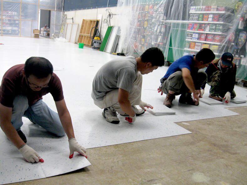 CAMP CASEY, Republic of Korea -- Construction workers at Camp Casey, Republic of Korea, cut floor tile July 14 for the renovation of the Camp Casey Post Exchange. (Photo courtesy of Stan Young, Yongsan Garrison Post Exchange)