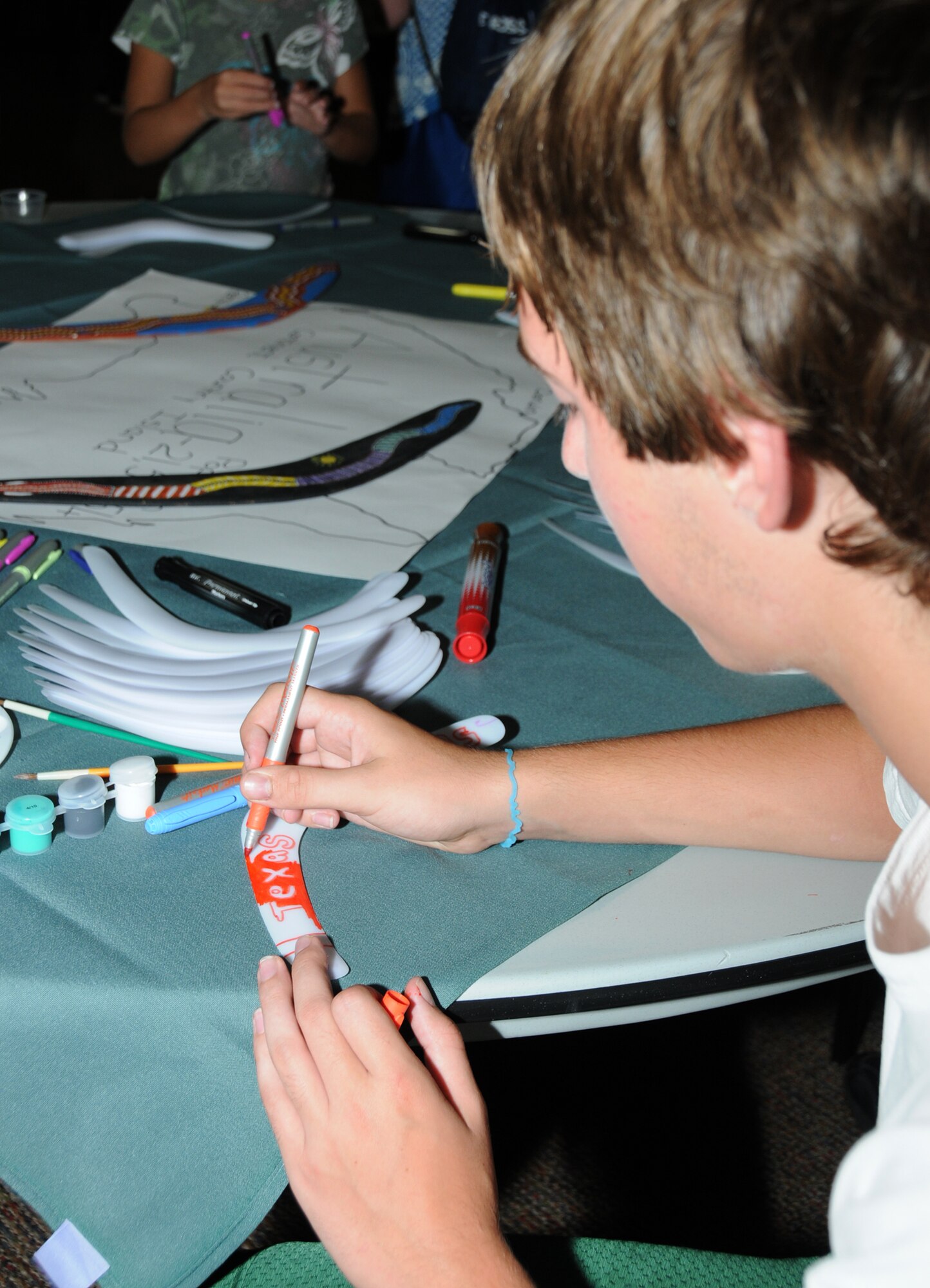 Dalton Andrews, 13, creates his own art on a boomerang at the Australia booth during Diversity Day, July 20 at the Dragon's Lair.  His mom is Staff Sgt. Mindy Dahl, 335th Training Squadron.  (U.S. Air Force photo by Kemberly Groue)