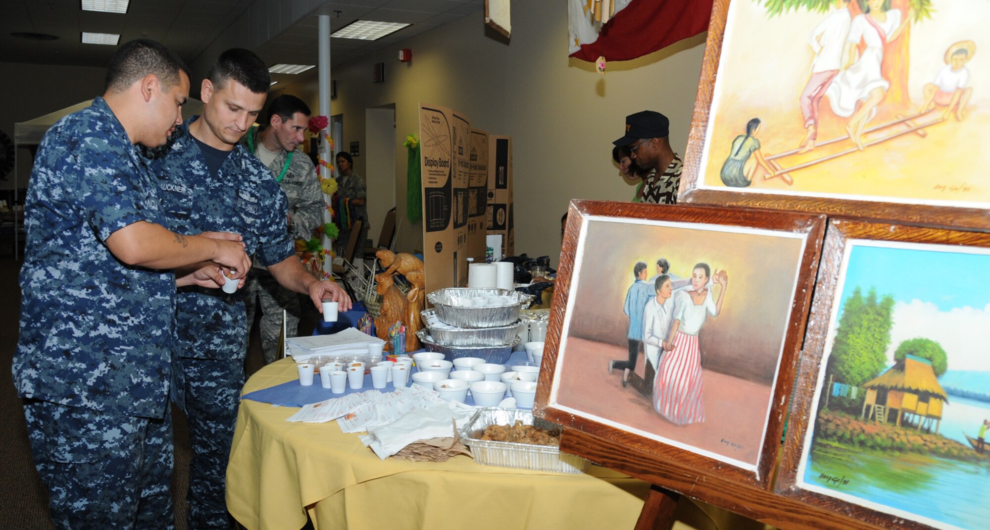 Electrician Mates 1st Class Jose Aranda, left, and Trinity Lauckner sample lumpia, a Philippine egg roll, during Diversity Day, July 20 at the Dragon's Lair.  (U.S. Air Force photo by Kemberly Groue)