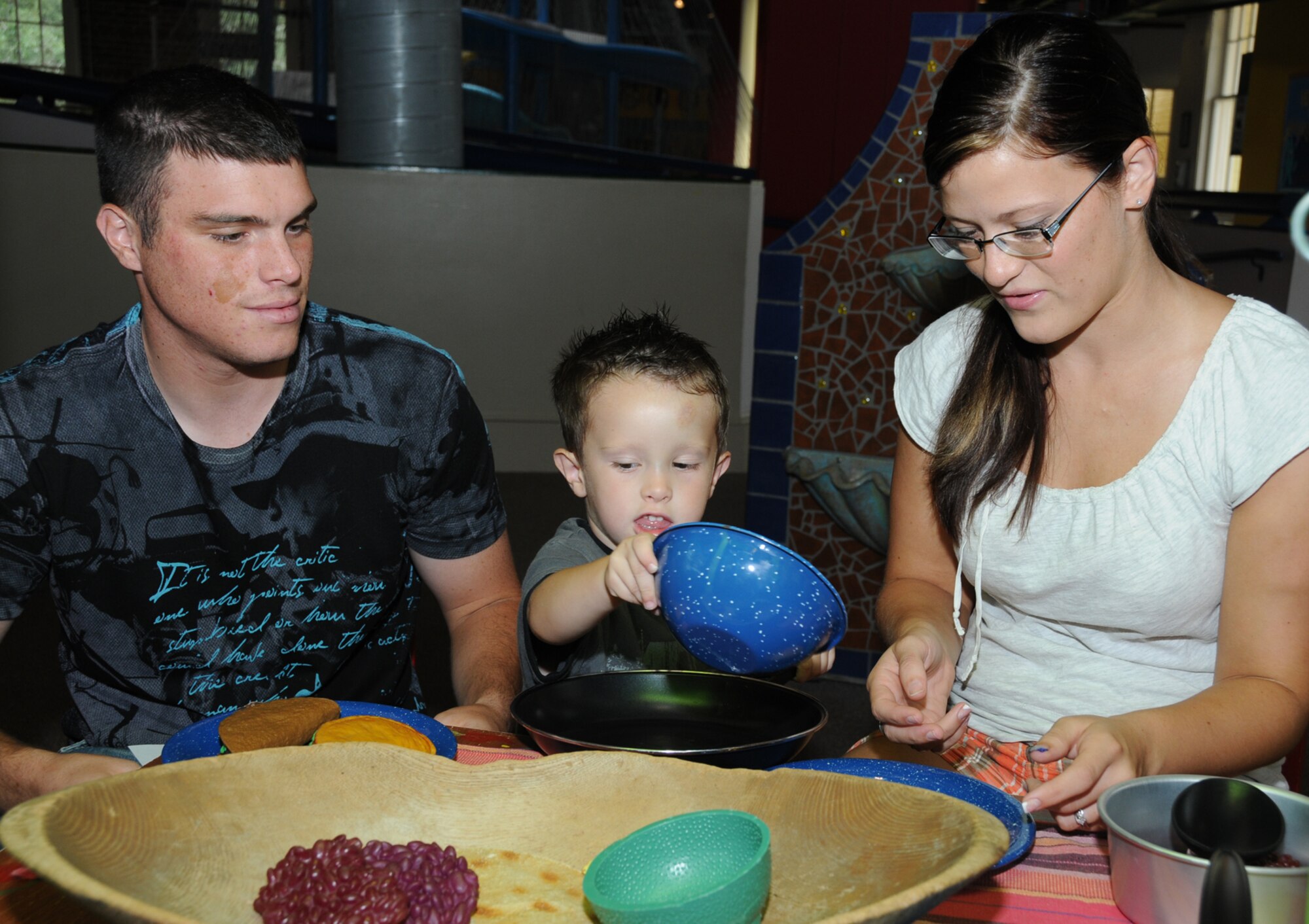 Three-year-old Kaydence Hughes serves “Mexican food” to his parents, Airman 1st Class Jeremy and Trisha Hughes, Saturday at the Lynn Meadows Discovery Center in Gulfport. Airman Hughes is a student in the 338th Training Squadron. The special day for military families featured free food, games, scavenger hunts and prizes. The celebration was the airman and family readiness center’s final event for its Year of the Air Force Family observance which ends this month.  (U.S. Air Force photo by Kemberly Groue)