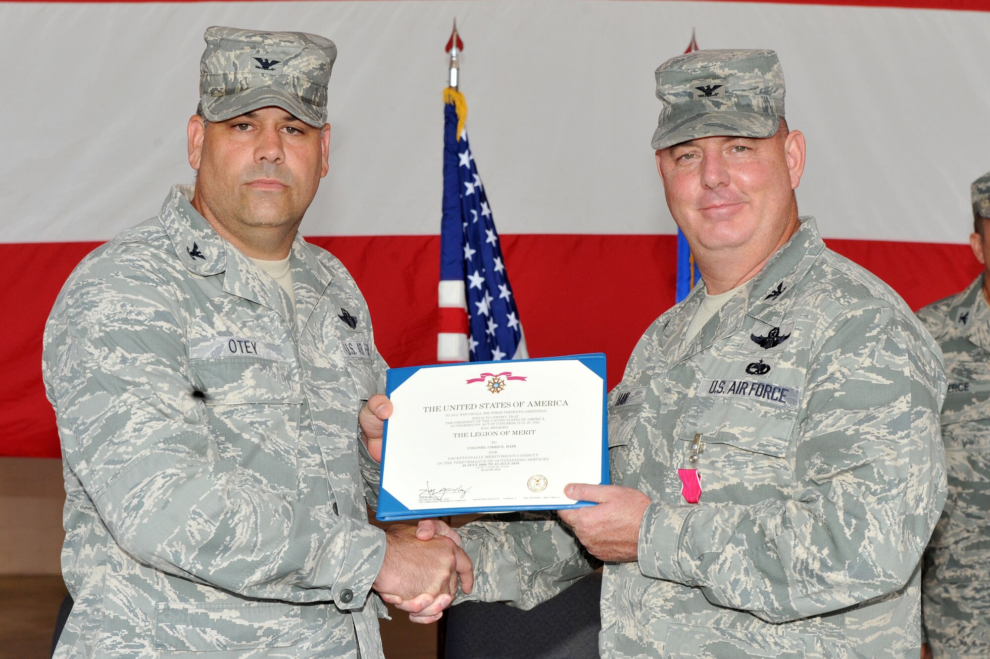 Col. Greg Otey, 19th Airlift Wing commander, presents the Legion of Merit to Col. Christopher Hair, 19th Maintenance Group out-going commander, during a change of command ceremony July 23 on base. Colonel Hair served more than 20 months honorably and contributed his success as a commander to the men and women of the 19th MXG. (U.S. Air Force photo by Senior Airman Steele C. G. Britton)