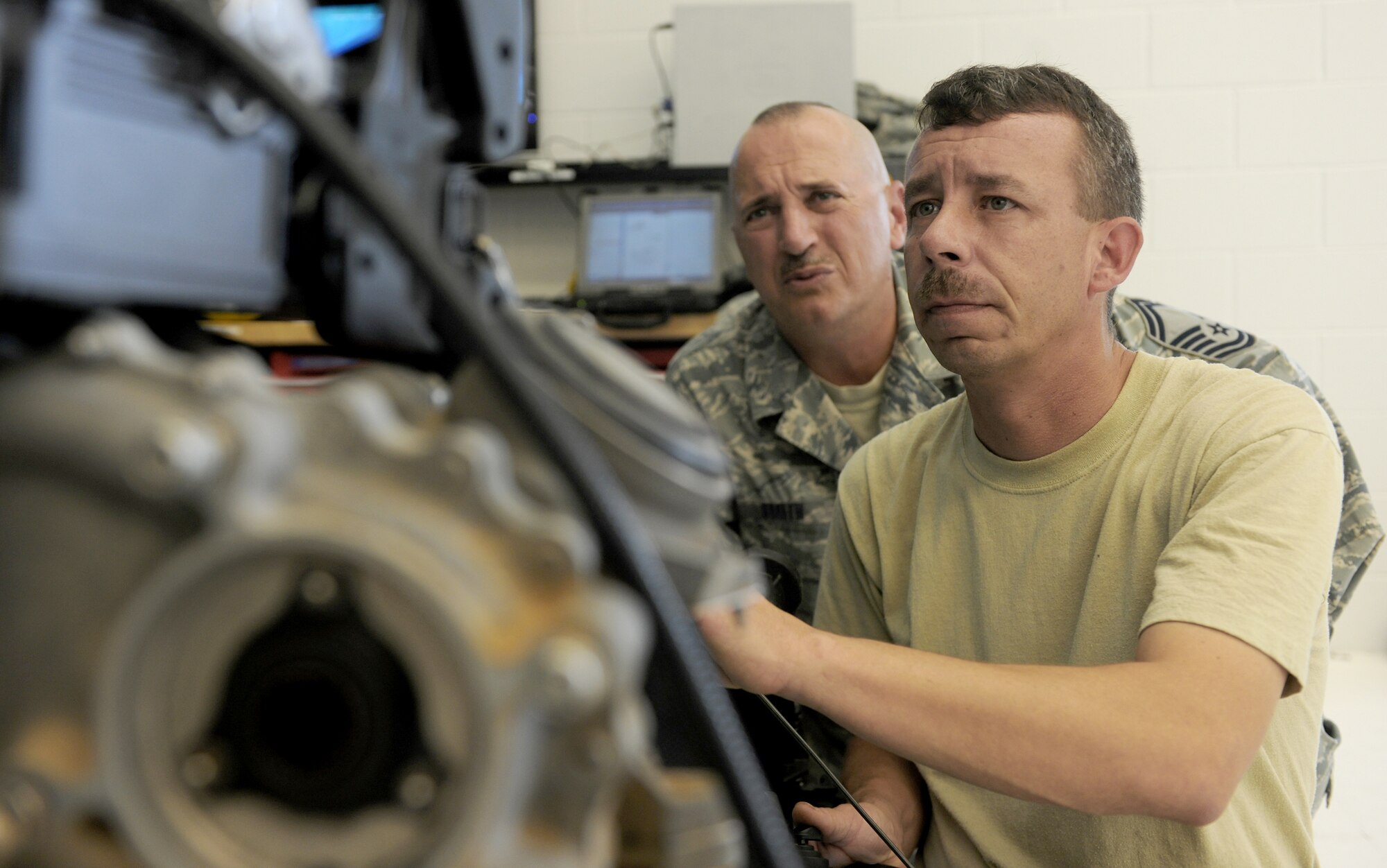 Senior Master Sgt. David Smith observes Tech. Sgt. Charles Carpentier while he examines the inside of a TF-34 engine July 22, 2010, at Moody Air Force Base, Ga. Sergeant Smith is the 23rd Component Maintenance Squadron propulsion flight chief. Sergeant Carpentier is the 23rd CMS combat search and rescue propulsion section chief. Sergeants Smith and Carpentier are working together to train aerospace propulsion technicians to work on any of the three aircraft engines there. (U.S. Air Force photo/Airman 1st Class Benjamin Wiseman)