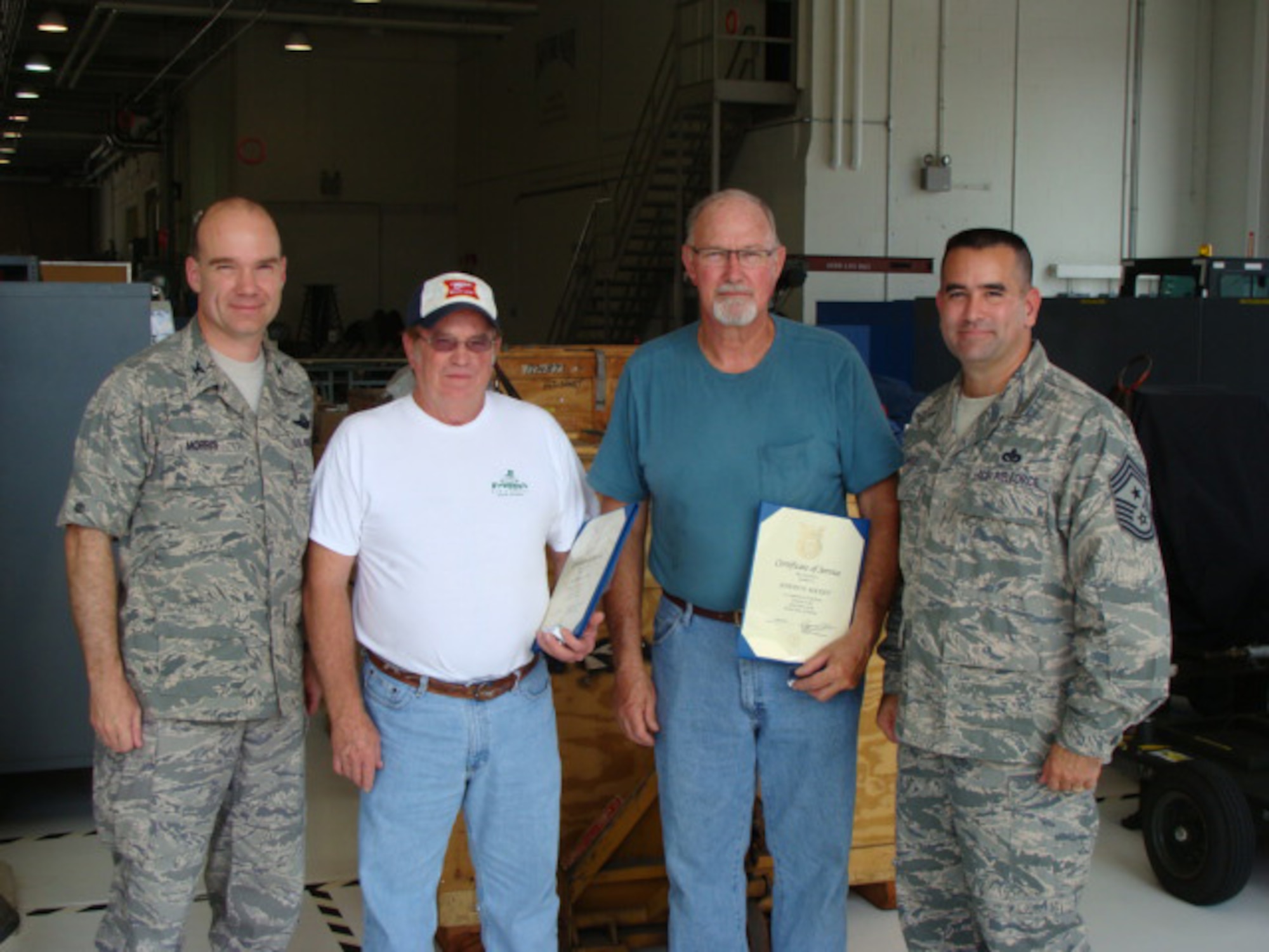 Col. Manson Morris, 436th Airlift Wing commander and Chief Master Sgt. John Evalle, 436th Airlift Wing Command Chief, present Mr. Allen Cote and Mr. Joseph Rockey with certificates and pins marking 40 years of service to the Department of Defense on Dover Air Force Base, Del., July 19, 2010. Mr. Cote is a propulsion systems mechanic and Mr. Rockey is an aero-repair systems mechanic both with the 436th Maintenance Squadron. (Courtesy Photo)                            