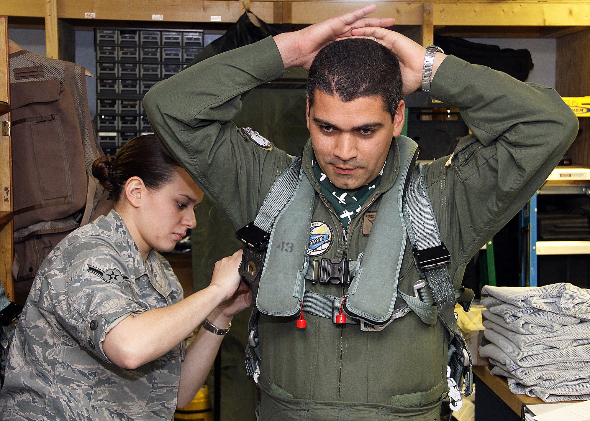 Airman Nina Thompson, 482nd Operations Support Squadron Aircrew Flight Equipment Specialist, helps Uruguayan Air Force Capt. Patrick Jaimez into a G-suit to prepare for a subject matter expert exchange flight at Homestead Air Reserve Base, Fla., on July 26. Capt. Jaimez was one of five pilots from the 2nd Air Brigade, Durzano, Uruguay who visited Homestead for a 3-day series of briefings, training and F-16 flights. (U.S. Air Force photo/Ian Carrier)