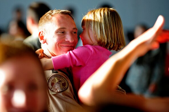 ELLSWORTH AIR FORCE BASE S.D.-- Capt. William Jacks, 34th Bomb Squadron B-1B Lancer pilot, hugs his seven-year-old daughter Rachel while waiting to receive his deployment bags, July 28. Captain Jacks deployed for six months to Southwest Asia in support of Operations Iraqi and Enduring Freedom. (U.S. Air Force photo/Staff Sgt. Marc I. Lane)