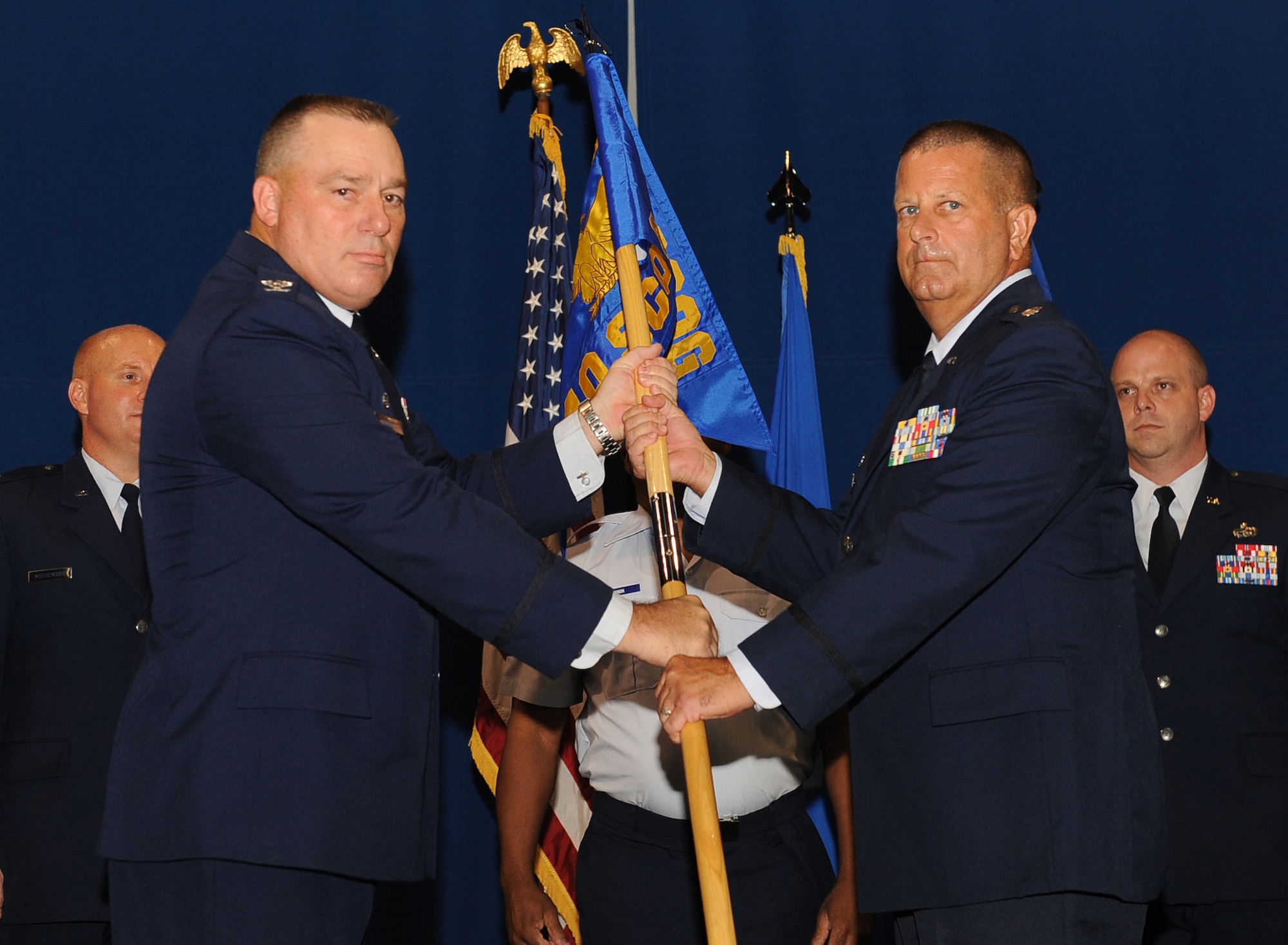 LANGLEY AIR FORCE BASE, Va. -- Col. Rick Bennett, 735th Supply Chain Operation Group commander, presents Lt. Col. John Denson, new 440th Supply Chain Operations Squadron director, with the 440th SCOS guidon during the activation, and assumption of commands ceremony July 22. Lieutenant Colonel Denson will be leading more than 195 active duty and civilian personnel.  (U.S. Air Force photo/ Senior Airman Gul Crockett)