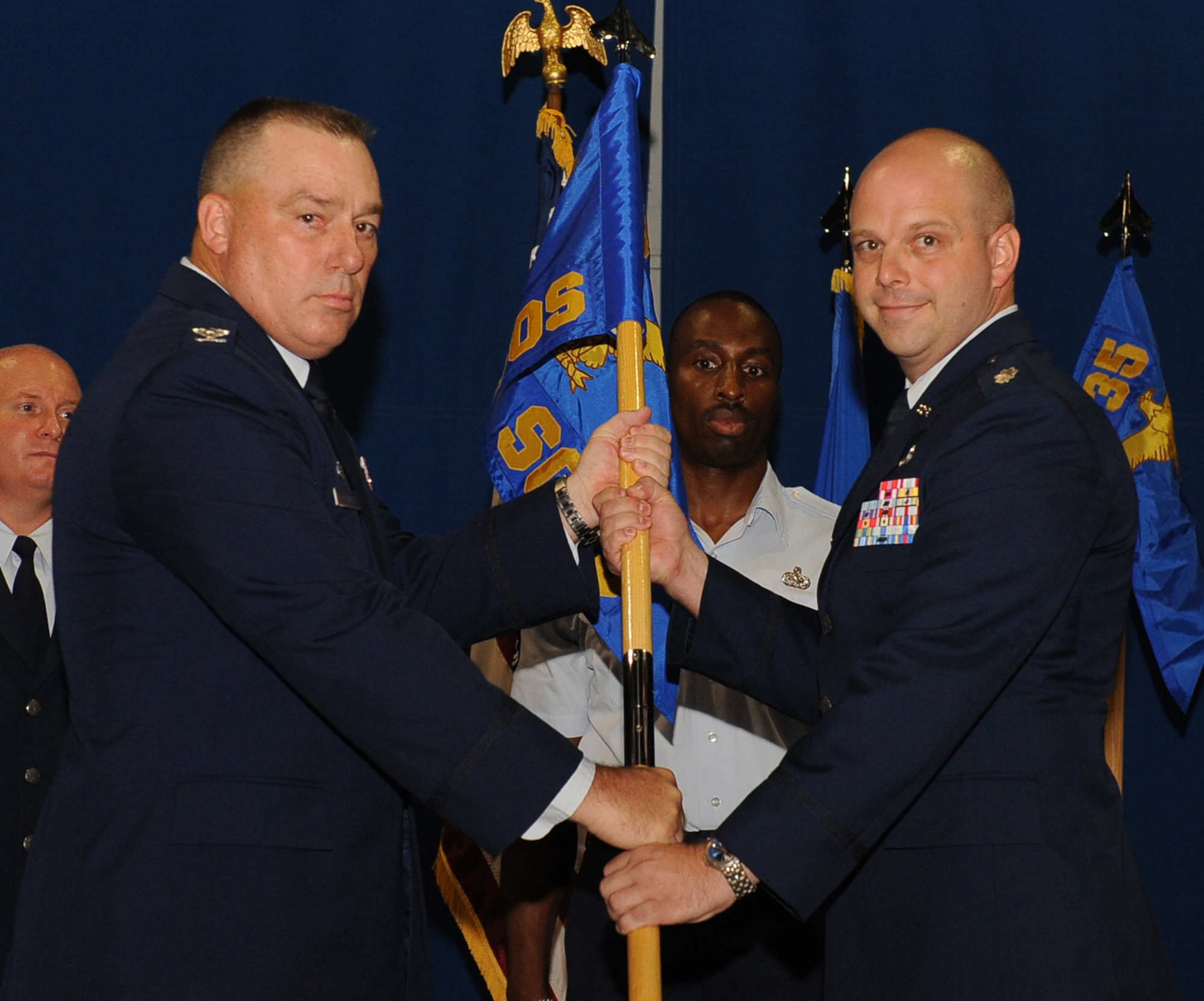 LANGLEY AIR FORCE BASE, Va. -- Col. Rick Bennett, 735th Supply Chain Operation Group commander, presents Lt. Col. Eric Ellmyer, 439th Supply Chain Operation Squadron commander, with the 439th SCOS guidon during the activation, and assumption of commands ceremony July 22. Lieutenant Colonel Ellmyer will be leading more than 200 active duty, guard, and civilian personnel, and managing over 1185, bomber and special mission aircraft.  (U.S. Air Force photo/ Senior Airman Gul Crockett)