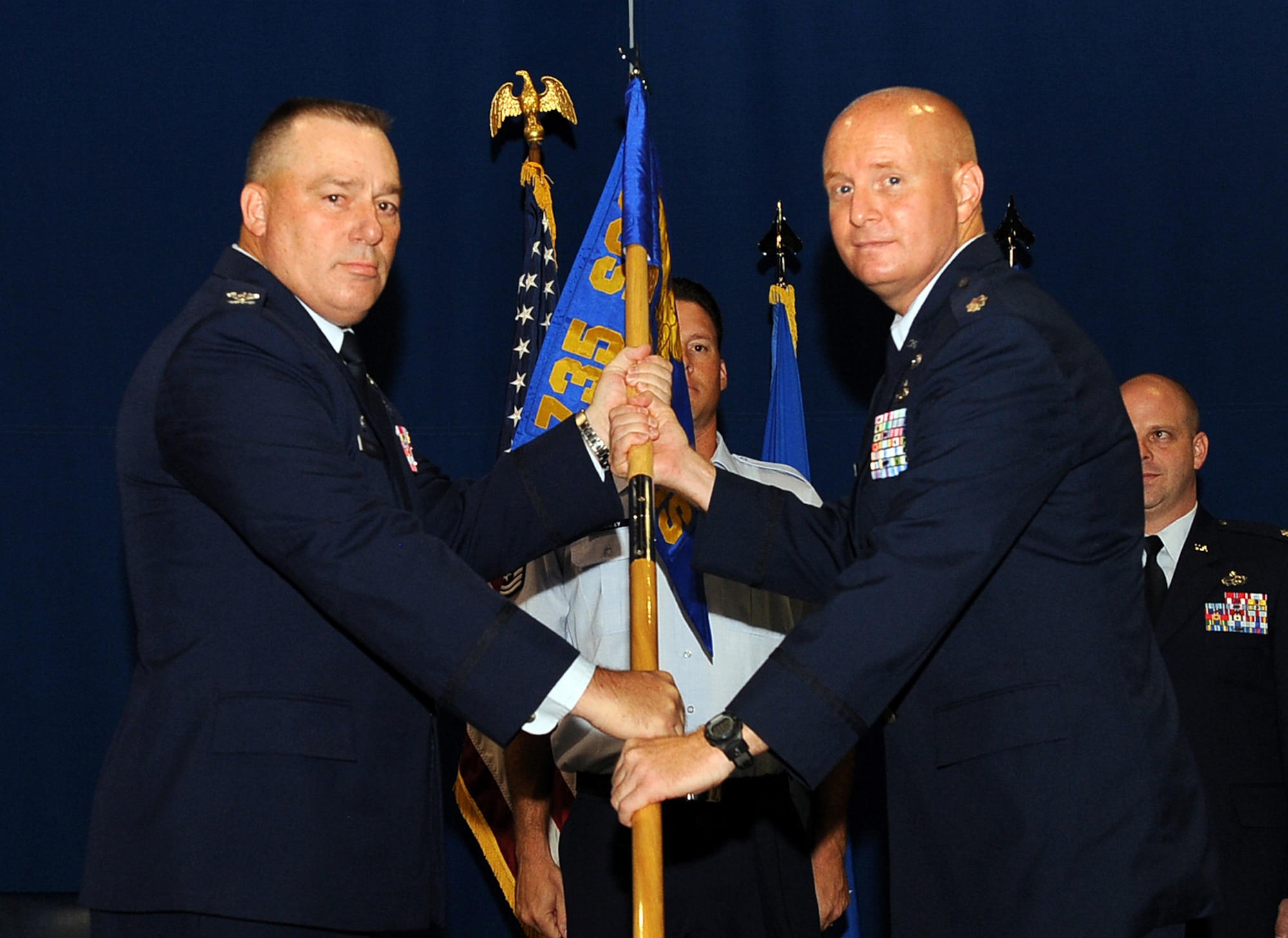 LANGLEY AIR FORCE BASE, Va. -- Col. Rick Bennett, 735th Supply Chain Operations Group commander, presents Lt. Col. Joseph Moehlmann, 438th Supply Chain Operations Squadron commander, with the 438th SCOS guidon during the activation, and assumption of commands ceremony July 22.  Lieutenant Colonel Moehlmann will be leading more than 190 active duty, guard, and civilian personnel, and managing 1,800 fighter aircraft. (U.S. Air Force photo/ Senior Airman Gul Crockett)