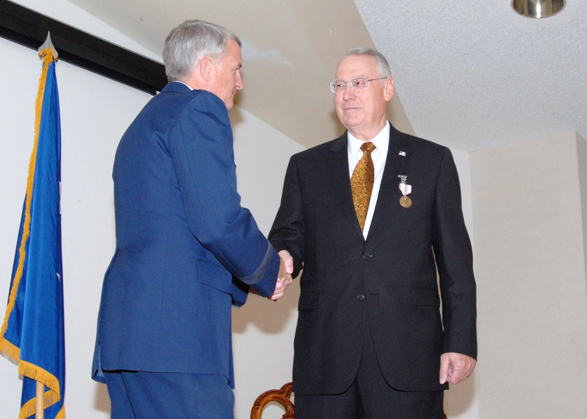 Mike Maher, Air Force Flight Test Center Manpower and Personnel director, is congratulated by Maj. Gen. David J. Eichhorn, AFFTC commander, at a retirement luncheon and ceremony at Club Muroc, July 28.  Mr. Maher has served 25 years as a government civilian and 22 years of active duty in the Air Force.  He has spent the last 10 years here at Edwards.  Mr. Maher received several awards and certificates during his retirement luncheon. (Air Force photo by Kenji Thuloweit)