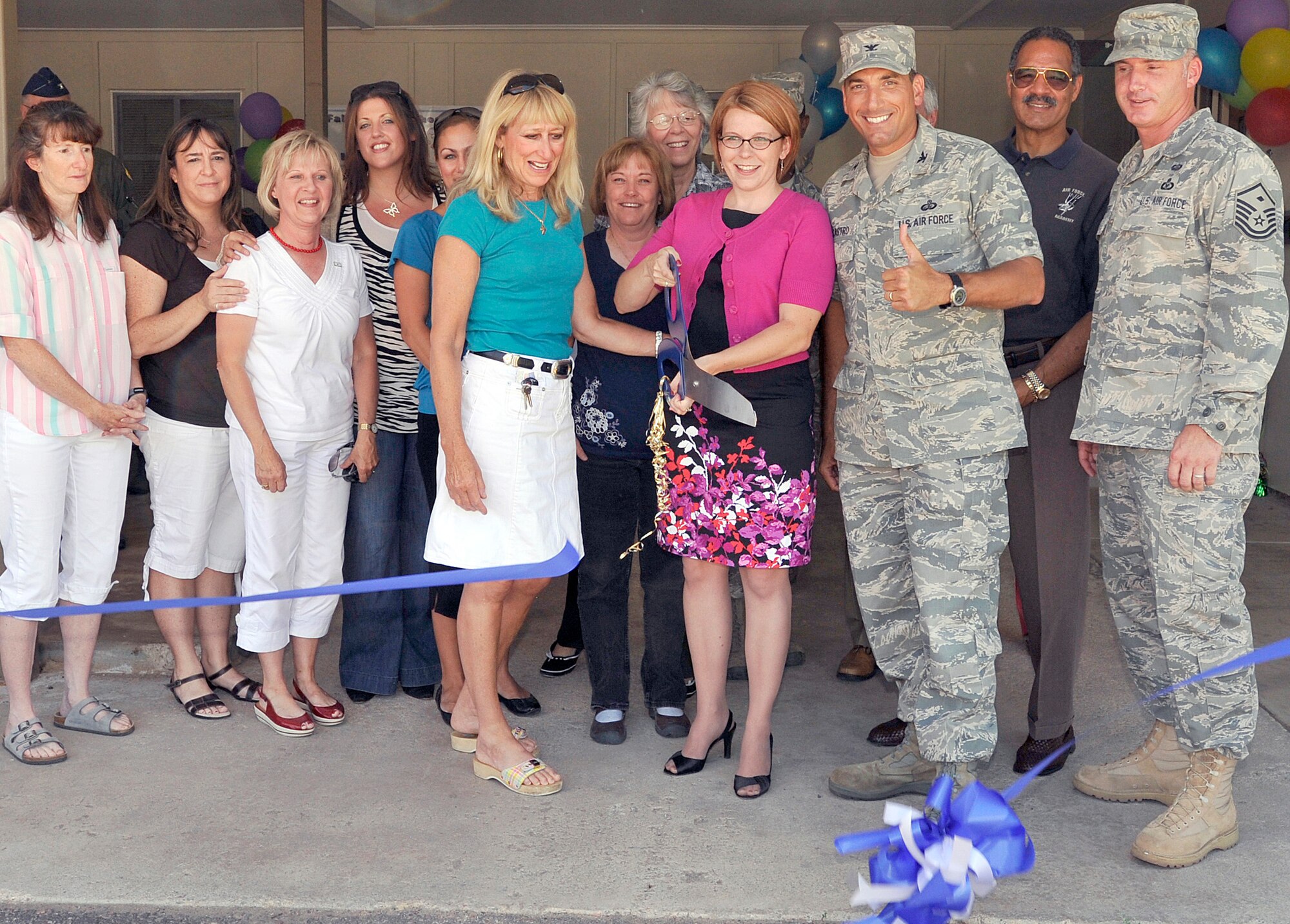 Cassie Nordin (center, holding scissors) cuts a ribbon to celebrate the grand reopening of the Air Force Academy Airman's Attic in Douglass Valley Housing July 27, 2010. Also pictured are several Airman's Attic volunteers; Paula Gould, wife of Academy Superintendent Lt. Gen. Mike Gould; Col. Rick LoCastro, 10th Air Base Wing commander; T. Thompson, Association of Graduates president and CEO; and Master Sgt. Greg Meinert, the Academy first sergeant. (U.S. Air Force photo/Bill Evans)