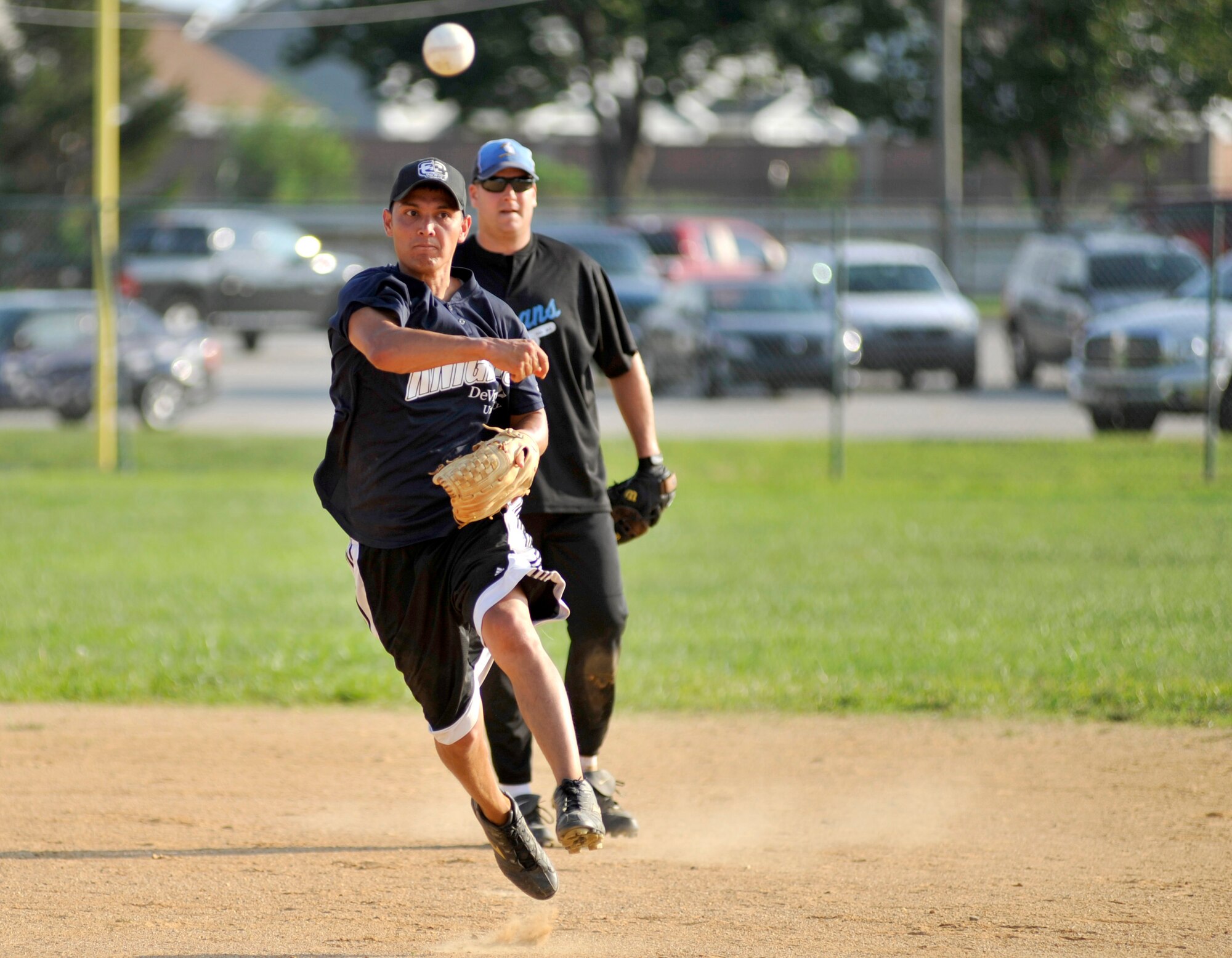 Josh Cutrer, 9th Airlift Squadron shortstop, attempts to throw a 436th Maintenance Squadron runner out at first base during a National League softball game at the base softball field on Dover Air Force Base, Del., July 27, 2010. Cutrer went 4-for-5 with two doubles, a home run and four RBI to lead the Pelicans to a 20-4 pasting of MXS. (U.S. Air Force photo by Tech. Sgt. Chuck Walker/Released)