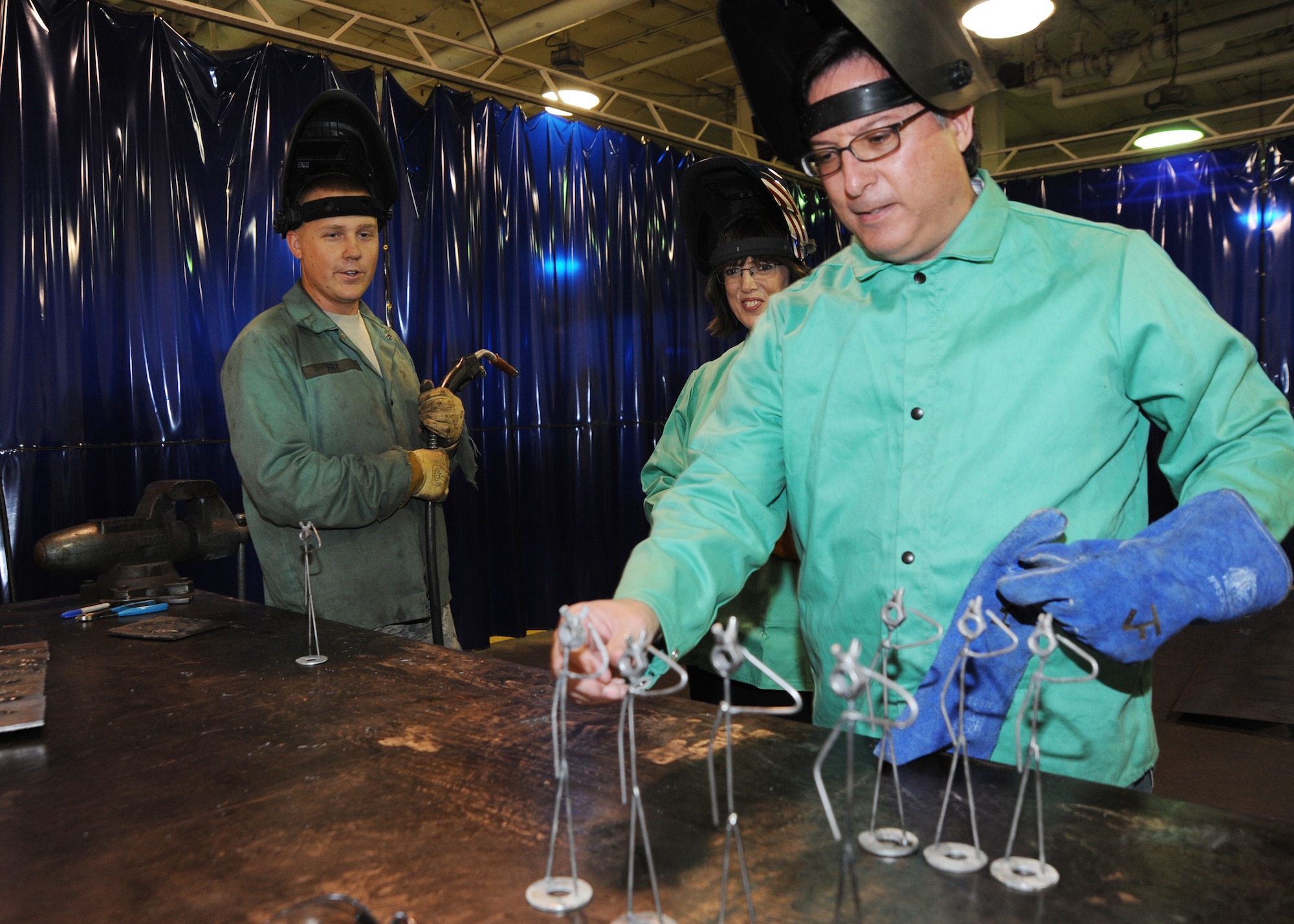 Anthony Powell and Jan Arnold, McConnell honorary commanders, pick from a selection of metal sculptures during a quarterly honorary commander tour as Staff Sgt. Jonathan Fry, 22nd Maintenance Squadron aircraft metals technology journeyman, stands by, July 22, 2010, McConnell Air Force Base, Kan.  The sculptures were created specifically for the honorary commanders from the 22nd Maintenance Group.  This quarter, the 22nd MXG hosted the tour.  (U.S. Air Force photo/Airman 1st Class Andrea Salazar)