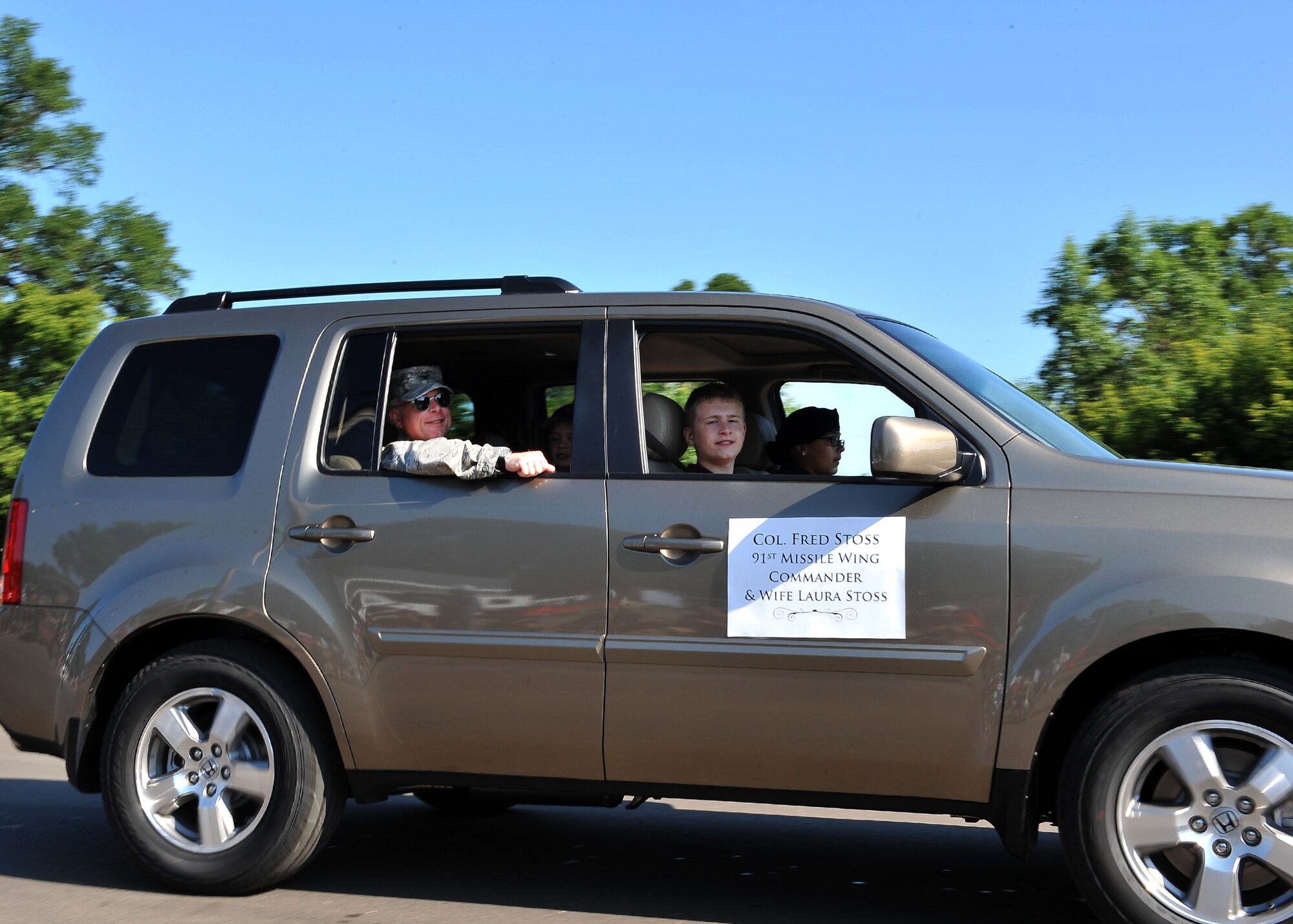 MINOT, N.D. -- Col. Fred Stoss, 91st Missile Wing commander, waves to the crowd during the North Dakota State Fair parade here July 24. Col. Doug Cox, 5th Bomb Wing commander, also participated in the parade. The 2010 North Dakota State Fair is open to the public until July 31. (U.S. Air Force photo by Senior Airman Michael J. Veloz)