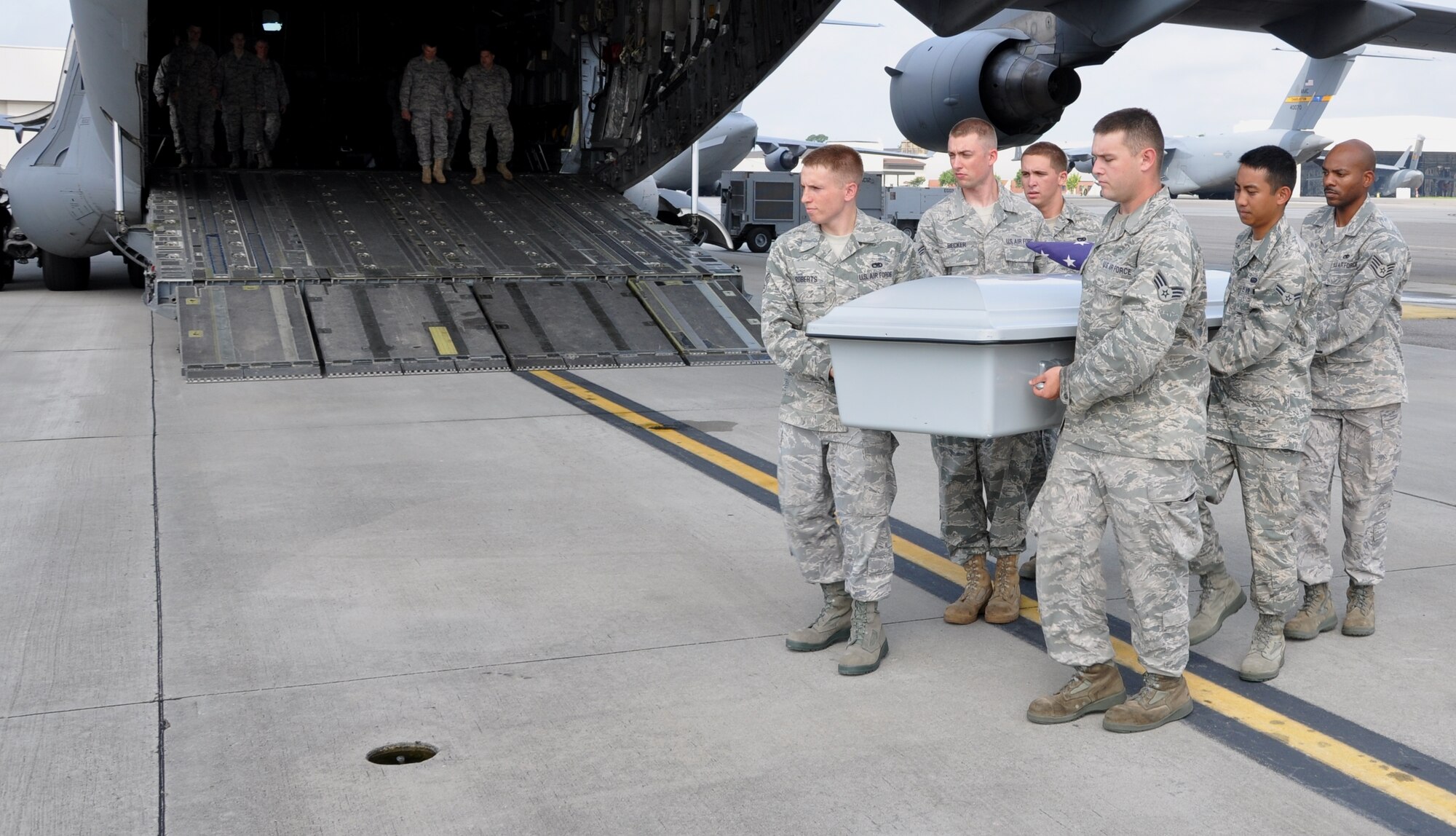 628th Joint Base Charleston honor guard members complete the casualty ramp ceremony training as they carry a training casket down the ramp of a C-17 Globemaster III here July 27. (U.S. Air Force photo/Staff Sgt. Shane Ellis)