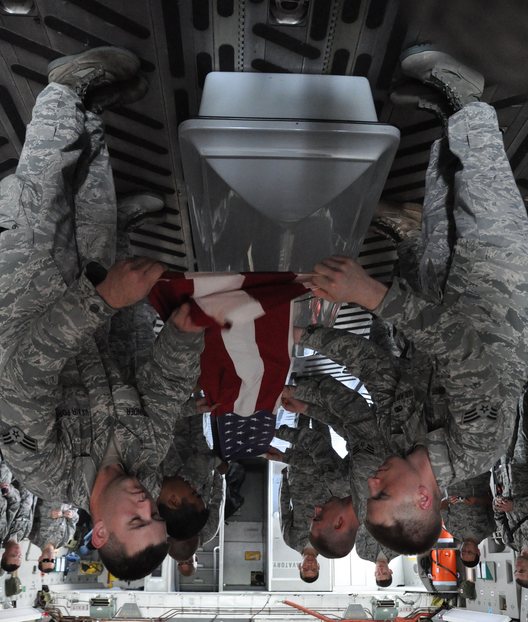 Chaplain candidates observe as 628th Joint Base Charleston honor guard members fold an American flag over the top of a training casket inside a C-17 Globemaster III here July 27. The chaplain candidates are with the Air Force Chaplain Candidate Intensive Internship Program. (U.S. Air Force photo/Staff Sgt. Shane Ellis)