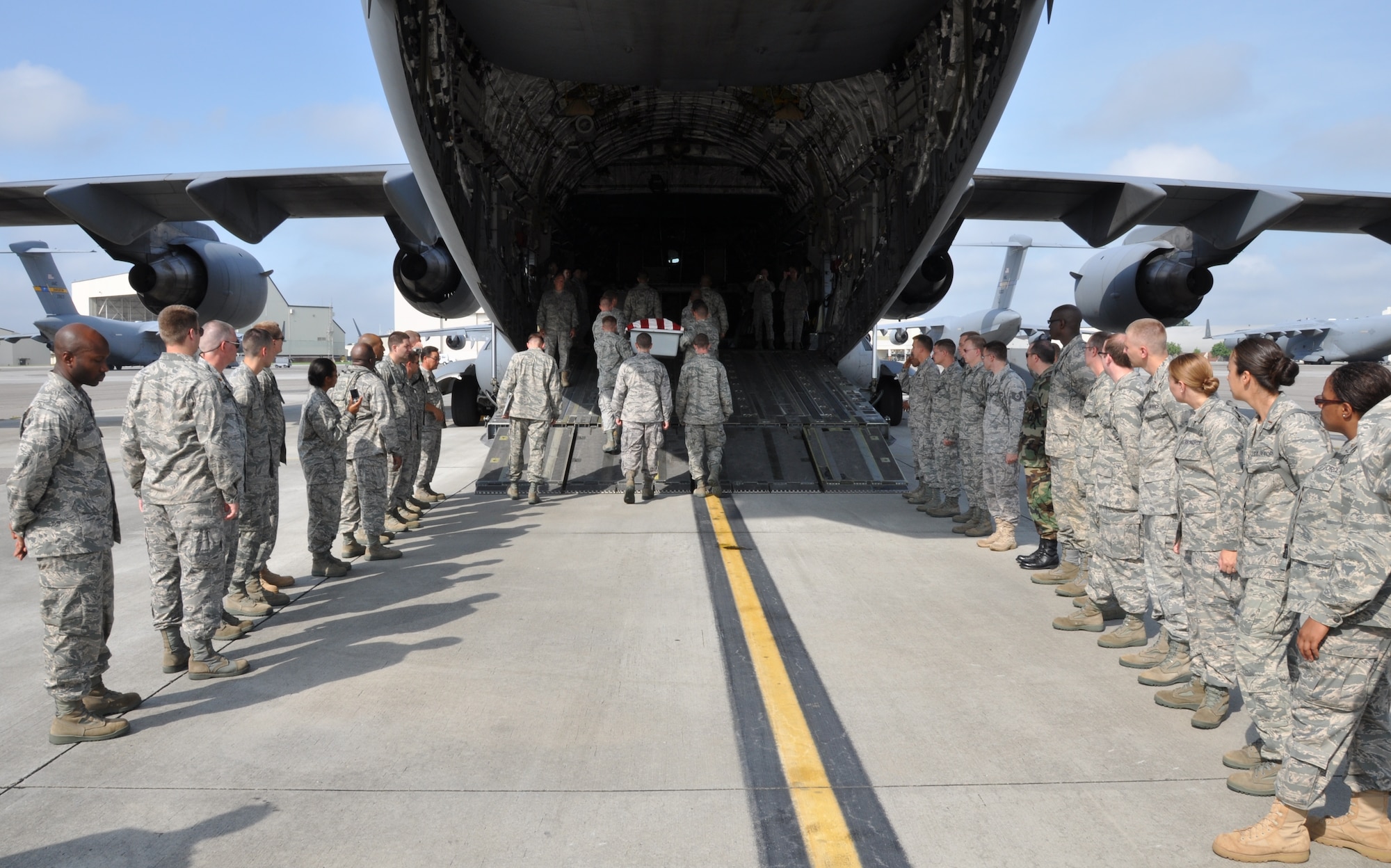 Chaplain candidates observe as 628th Joint Base Charleston honor guard members carry a training casket up the ramp of a C-17 Globemaster III here July 27. The chaplain candidates are with the Air Force Chaplain Candidate Intensive Internship Program. (U.S. Air Force photo/Staff Sgt. Shane Ellis)