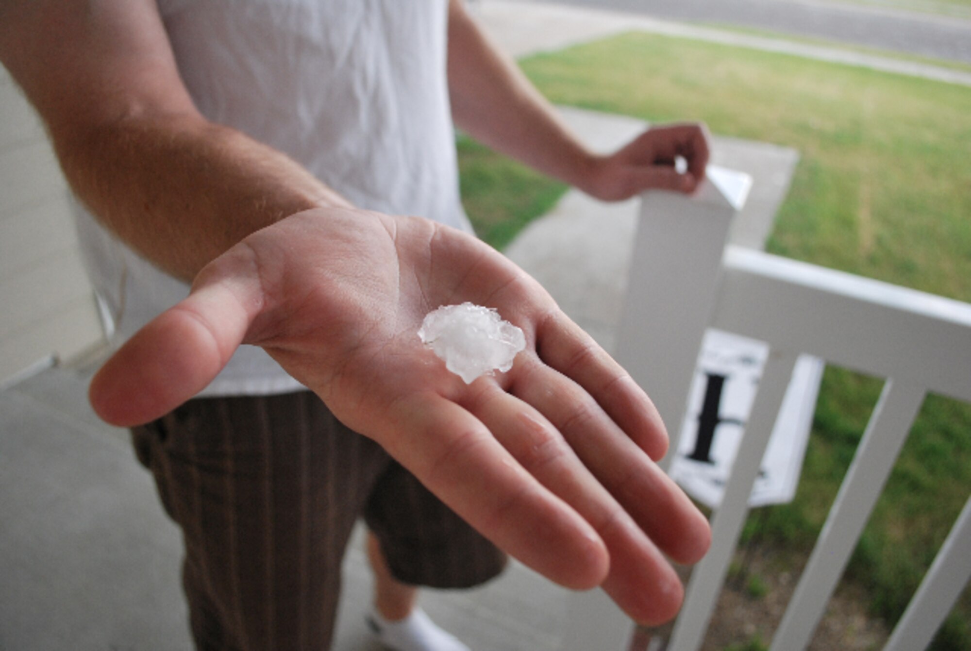 MINOT AIR FORCE BASE, N.D. – 1st Lt. Christopher Herman, 5th Medical Operations Squadron, holds a large piece of hail from an evening thunderstorm here July 26. Some hail from the storm measured up to 1 ¼ inches. (Courtesy photo by Nichole Herman)