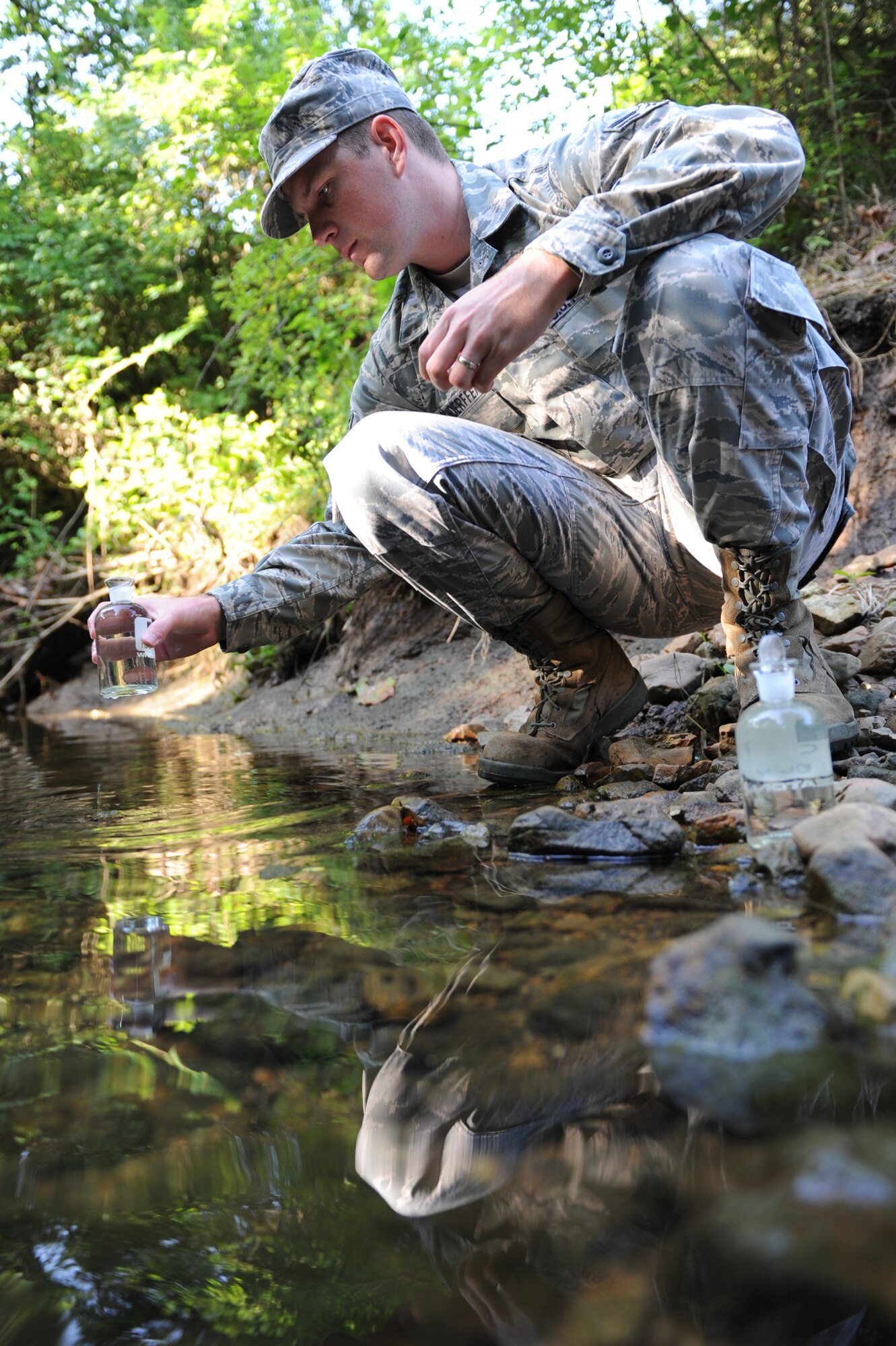 WHITEMAN AIR FORCE BASE, Mo.- Airman First Class Barry Hochderffer, 509th Civil Engineer Squadron, draws  a sample downstream from the treatment plant, July 22. This sample is the most crucial in the whole treatment process, measuring Whiteman's footprint on the local environment.(U.S. Air Force photo by Senior Airman Carlin Leslie) 
