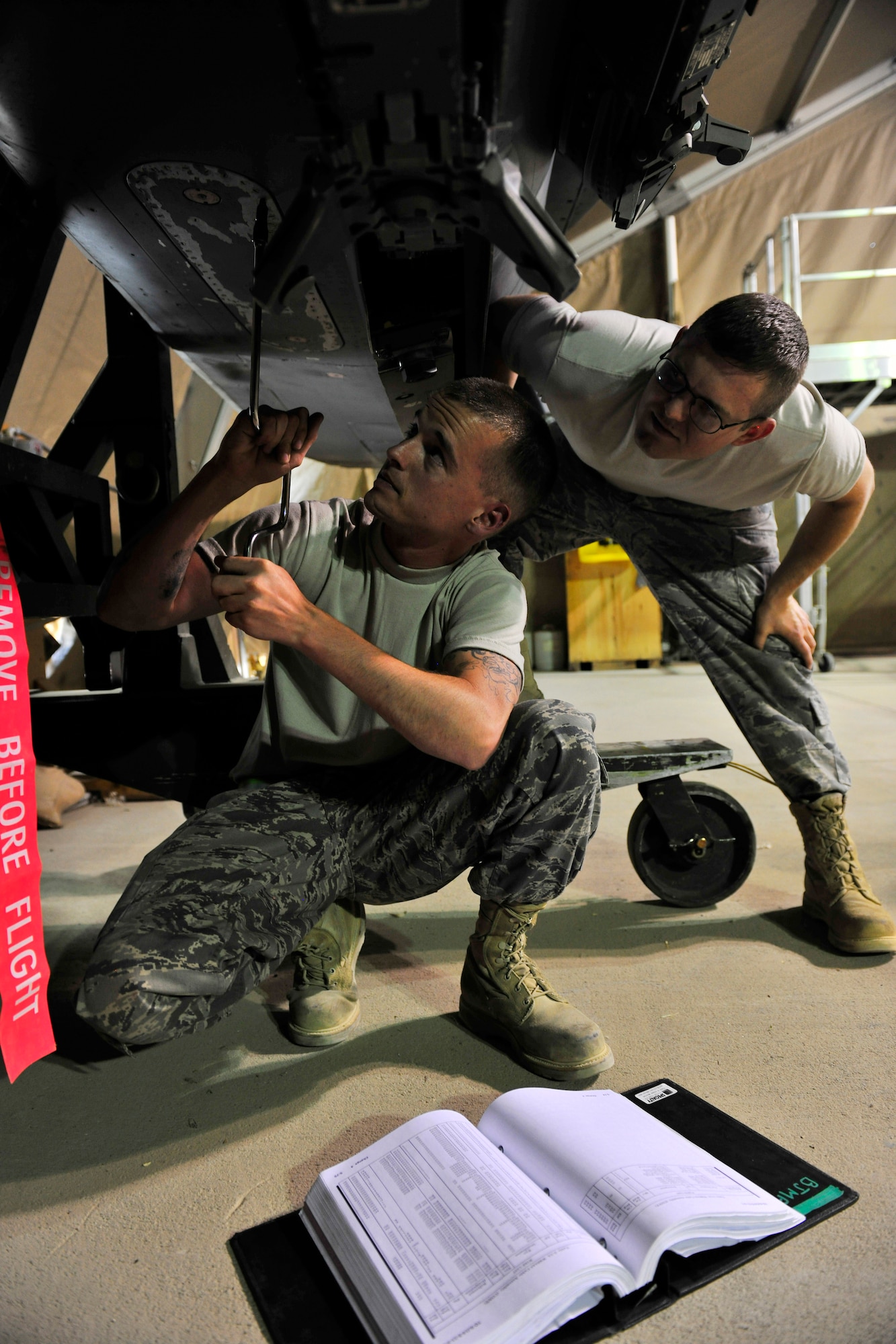 Left to right: Staff Sgt. Michael Teague and Senior Airman Ryan Houts, aircraft fuel systems repair journeymen assigned to the 455th Expeditionary Aircraft Maintenance Squadron, tighten a panel on a conformal fuel tank designed for an F-15E Strike Eagle at Bagram Airfield, Afghanistan, July 27, 2010. (U.S. Air Force photo/Staff Sgt. Christopher Boitz)