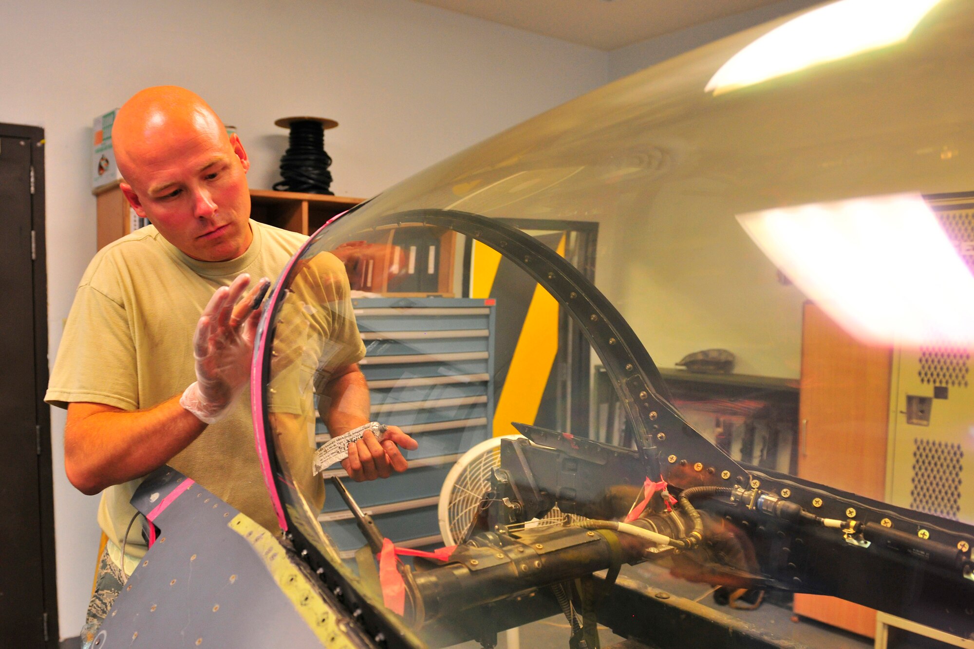 Tech Sgt. Jeremy Clark, an aircrew egress journeyman assigned to the 455th Expeditionary Maintenance Squadron, applies sealant to an F-16C Fighting Falcon canopy at Bagram Airfield, Afghanistan, July 27, 2010. The sealant will help keep the cockpit pressurized during flight. (U.S. Air Force photo/Staff Sgt. Christopher Boitz)