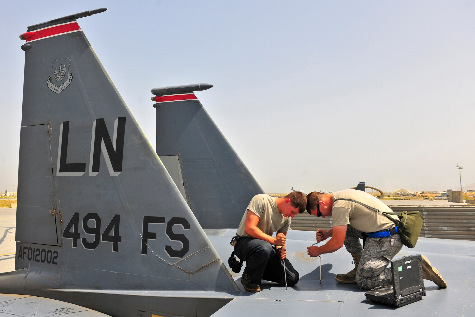 Senior Airman Corey Prater, a crew chief, and Senior Airman Brandon Blide, an avionics systems journeyman, both with 455th Expeditionary Aircraft Maintenance Squadron, fasten a panel on an F-15E Strike Eagle at Bagram Airfield, Afghanistan, July 27, 2010. (U.S. Air Force photo/Staff Sgt. Christopher Boitz)