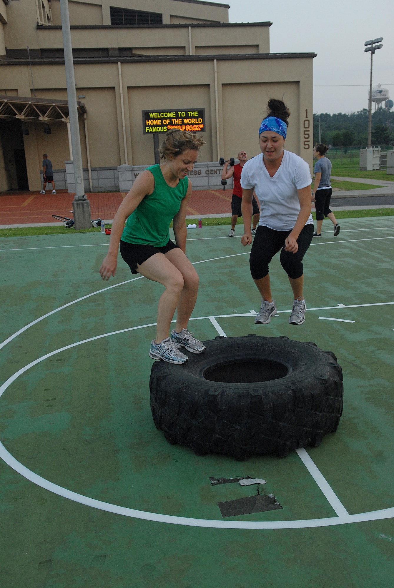 KUNSAN AIR BASE, Republic of Korea -- Capt. Melissa Thurman and 1st Lt. Fiona Dailey, both from the 8th Fighter Wing, jump on a tire after flipping it over during a CrossFit workout July 27. CrossFit combines aerobic workouts with strength training to increase strength, flexibility, agility and endurance. (U.S. Air Force photo/Senior Airman Roy Lynch)