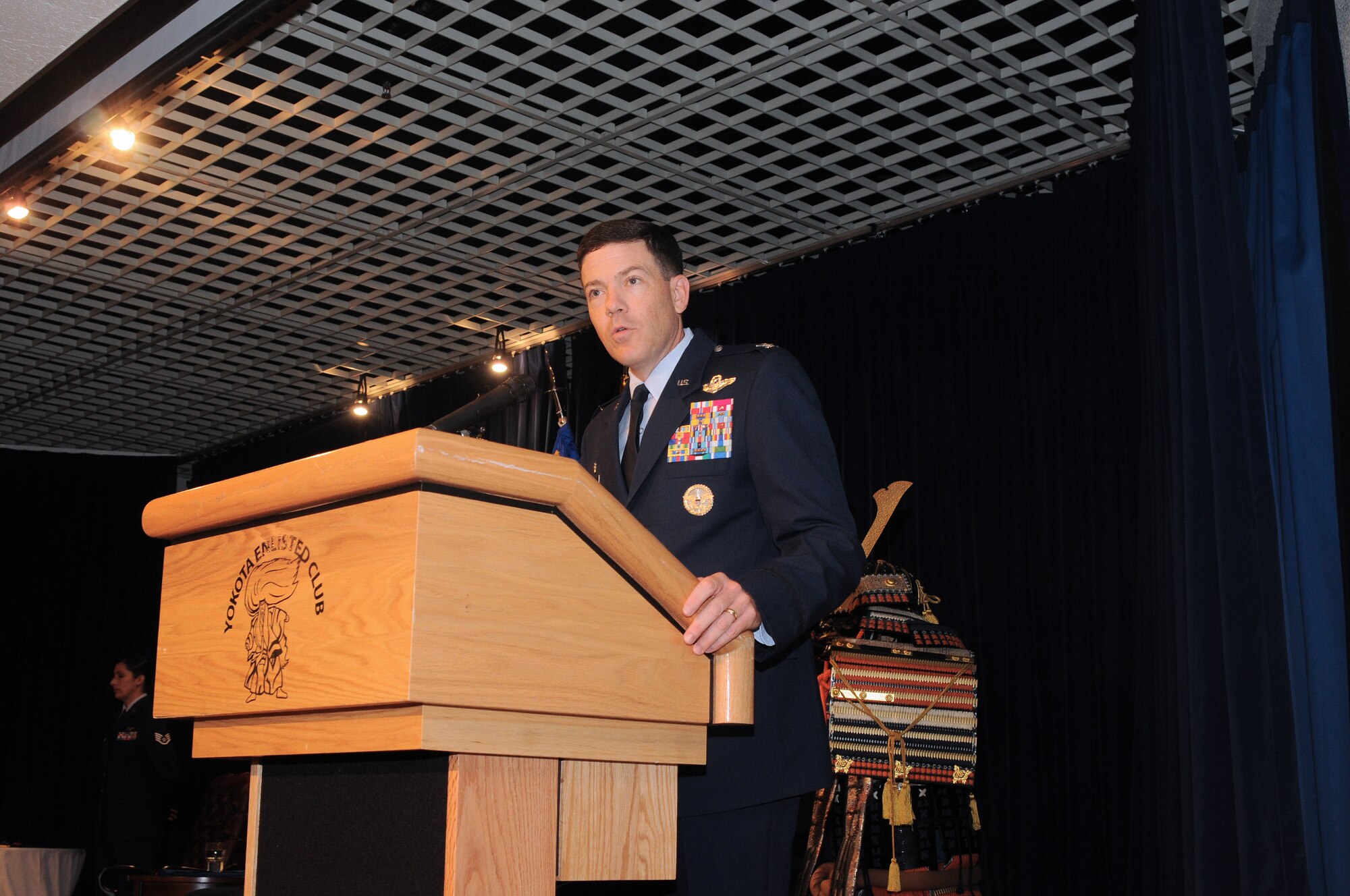 YOKOTA AIR BASE, Japan -- Col. Stephen Oliver Jr., 515th Air Mobility Operations Wing commander, speaks during the 515th Air Mobility Operations Group  change of command July 13, about Col. Robert Ricci, 515th AMOG commander. Colonel Ricci replaced Col. Mark Baker as commander of the 515th AMOG. (U.S. Air Force photo/Katrina R. Menchaca)