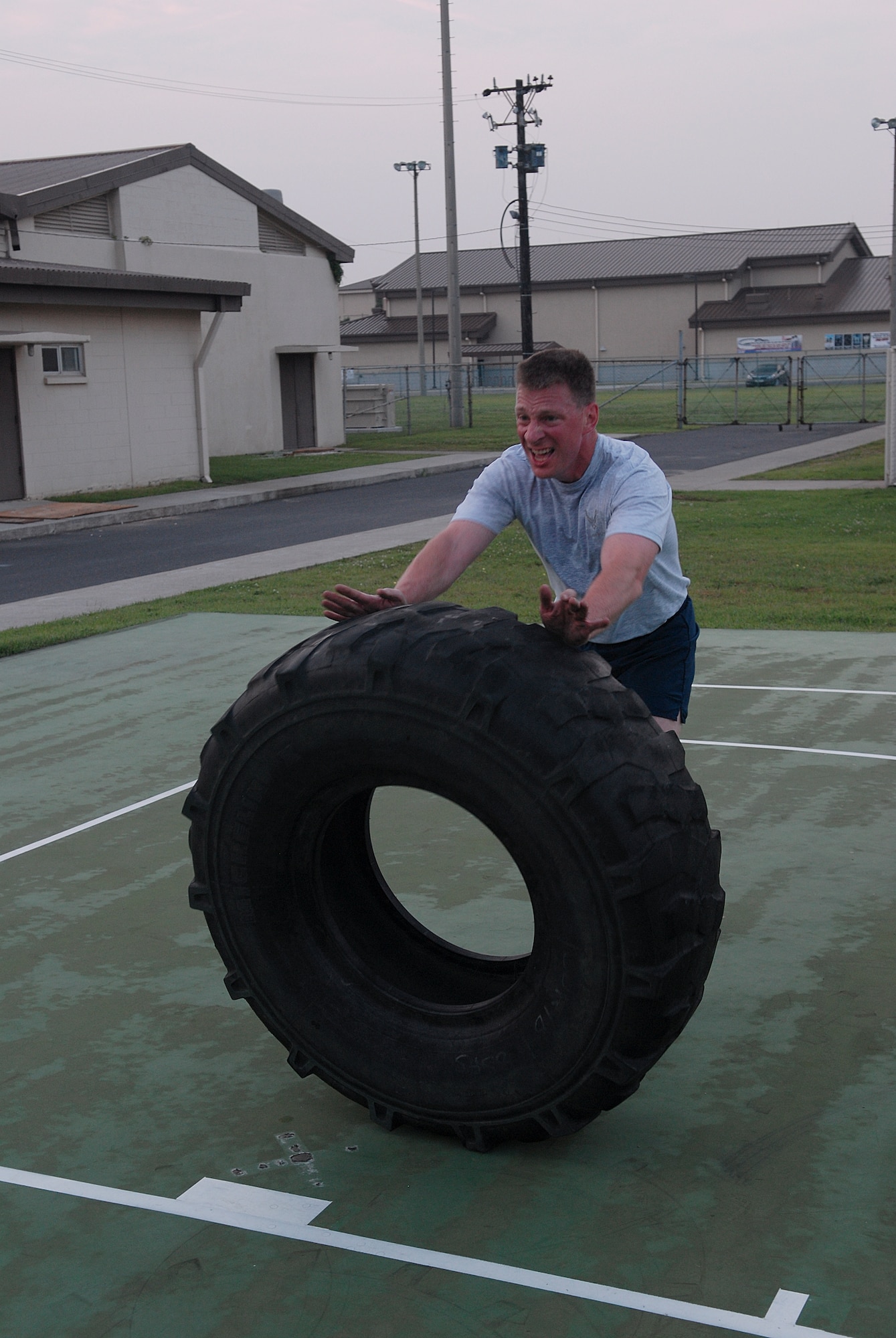 KUNSAN AIR BASE, Republic of Korea -- Col. John Dolan, 8th Fighter Wing commander, flips over a tire during a CrossFit workout July 27. CrossFit combines aerobic workouts with strength training to increase strength, flexibility, agility and endurance. (U.S. Air Force photo/Senior Airman Roy Lynch)